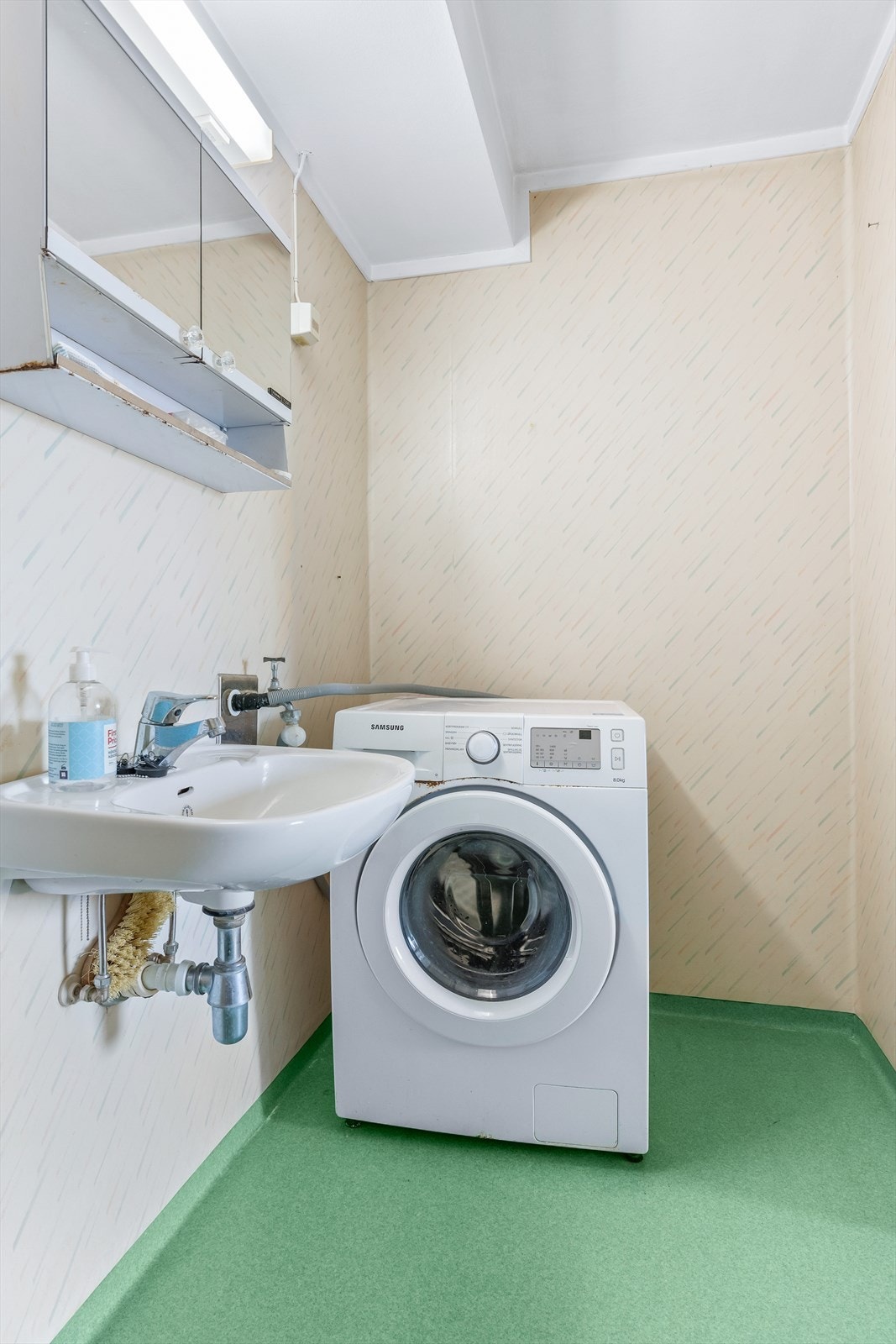 Baderommet har opplegg for vaskemaskin, servant, lys og speil. Galleribilde