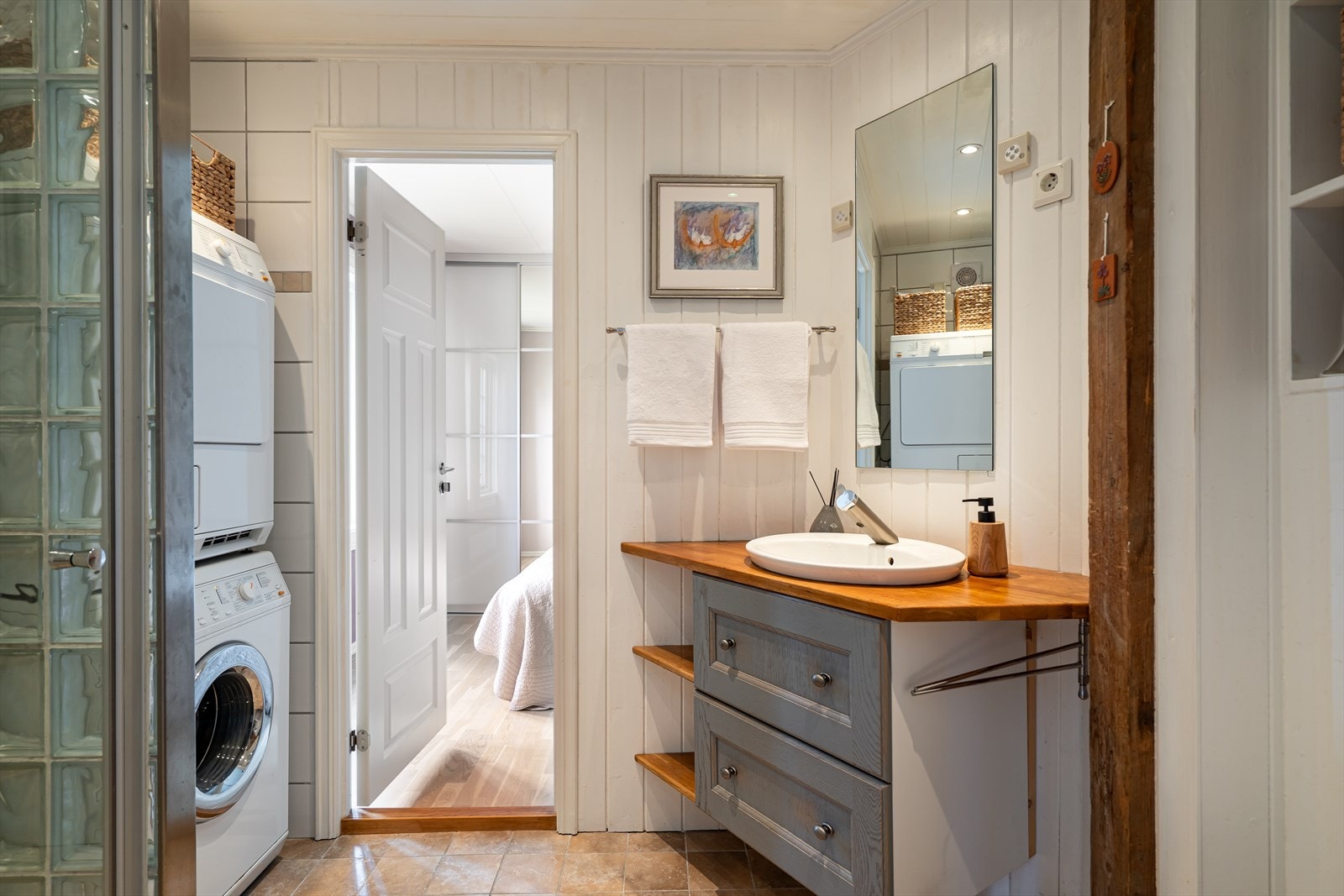 Badet fra 2011 har servant på innebygget underskap, speil med innebygget skap og downlights i himling. Vegghengt klosett og dusj med dusjvegg i herdet glass samt en vegg av glassbyggerstein. Varmekabler i gulv. Galleribilde