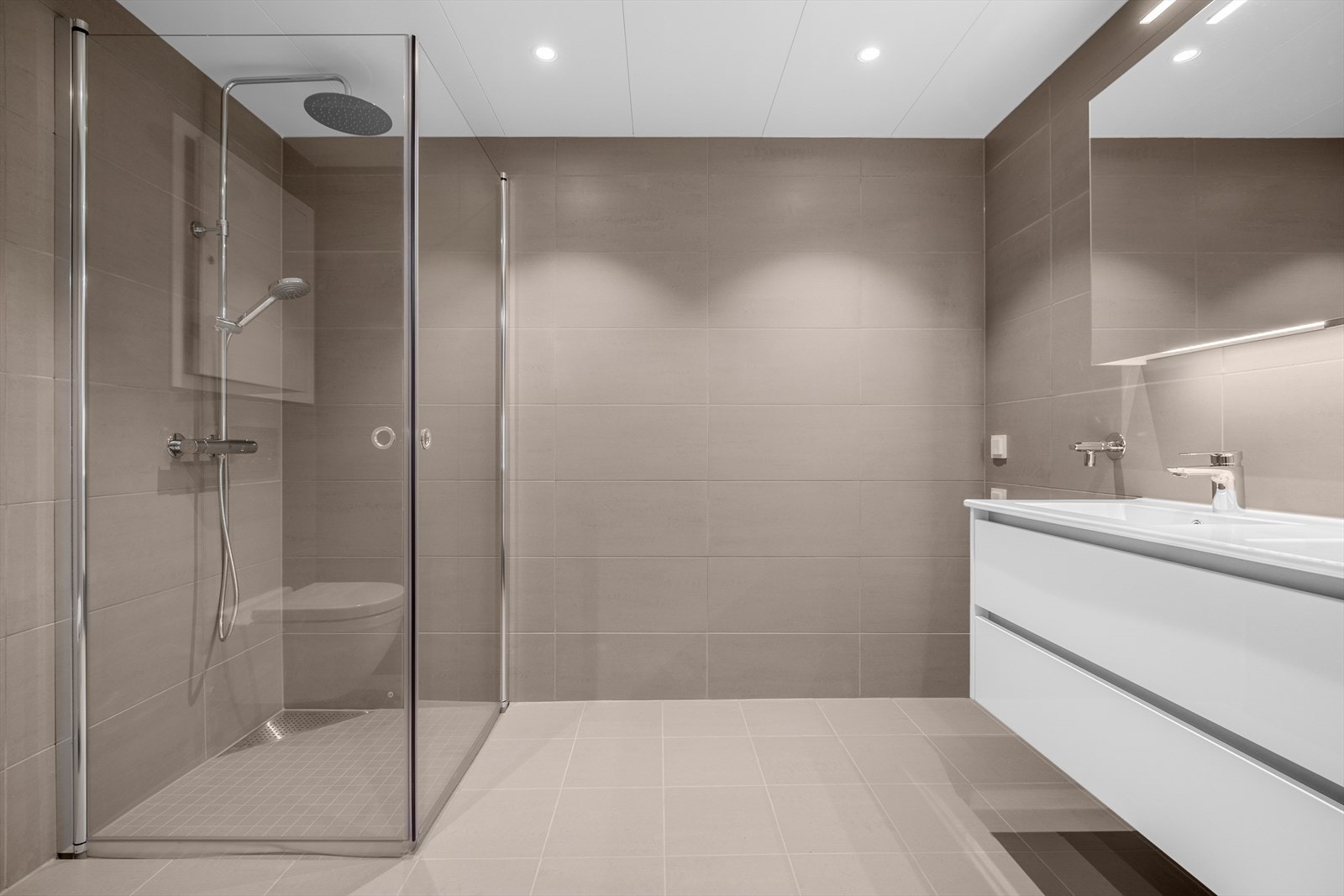 Badet er flislagt med behagelig gulvvarme Galleribilde