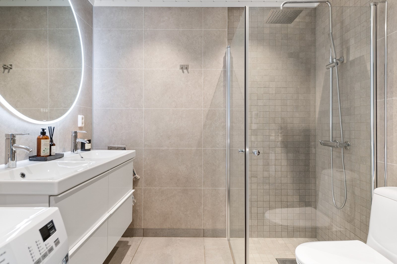 Boligen har et lyst og delikat baderom som ble pusset opp i 2020. Baderommet har store grå fliser på gulv med gulvvarme, overflater med våtromsplater kombinert med fliser i dusjsonen, downlights i himlingen og elektrisk styrt vifte. Galleribilde