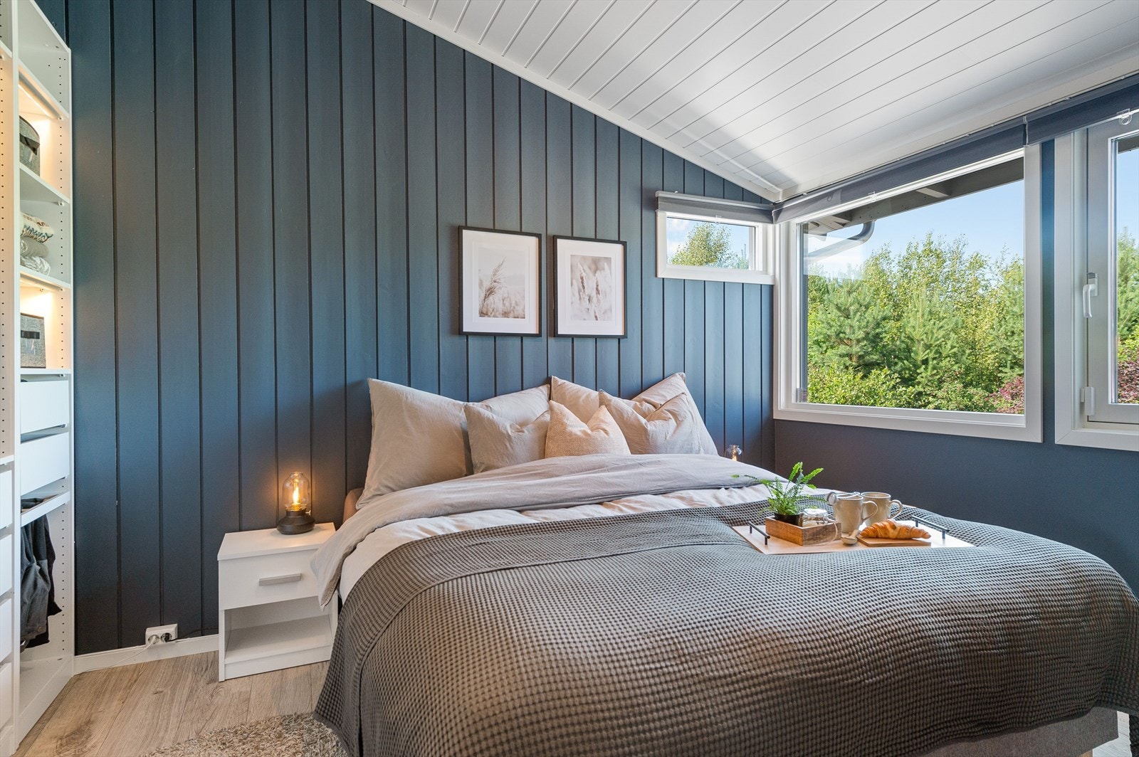 Soverommet har pen enstavs laminat på gulv og overflater malt i en fin og behagelig mørk blåfarge. Galleribilde