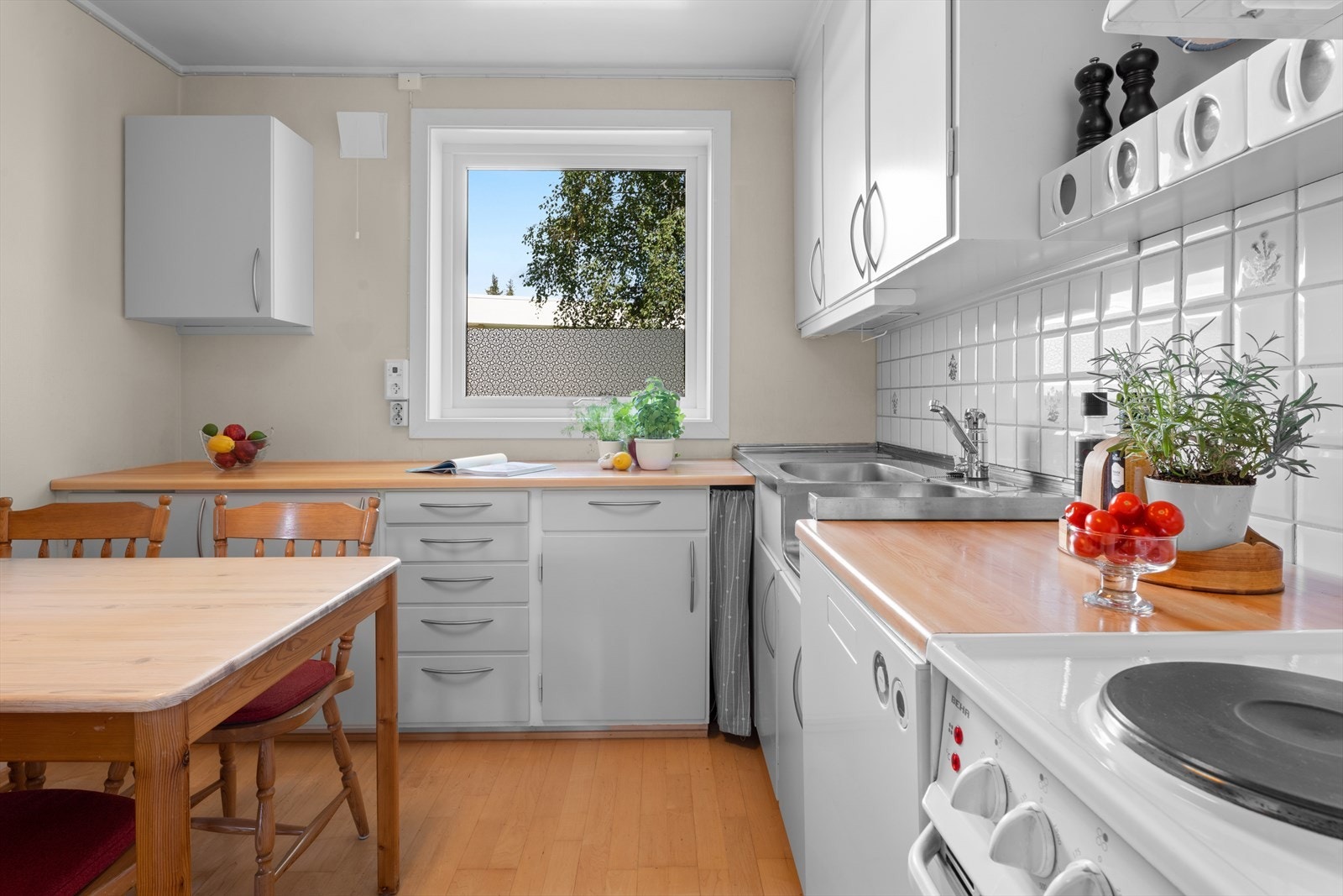 - Kjøkkenet har glatte fronter, stålbeslag med vask- og skyllekum, samt fliser og belysning over benkeplaten - Galleribilde