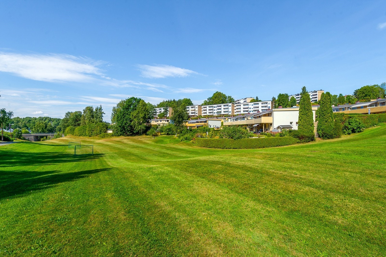 Store grøntarealer med fotballbane, akebakke og lekeplass Galleribilde
