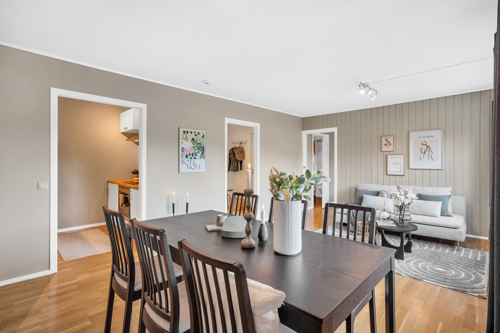 Romslig stue malt i en moderne fargetone med rikelig plass til etablering av både sitte- og spisegrupper. Galleribilde