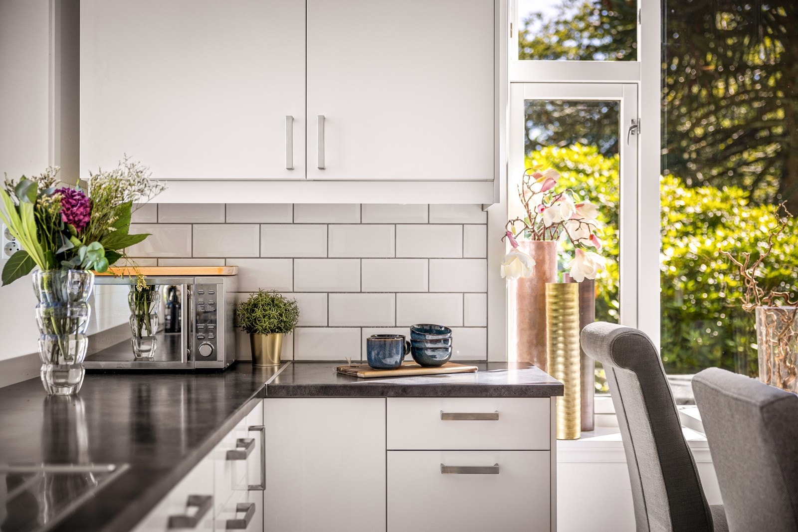 Kjøkkeninnredning fra IKEA med høyglans fronter, benkeplate i laminat og nedfelt stålvask med skyllekum, avrenningsbrett og ett-greps blandebatteri. Fliser over benkeplate. Det er montert komfyrvakt. Galleribilde