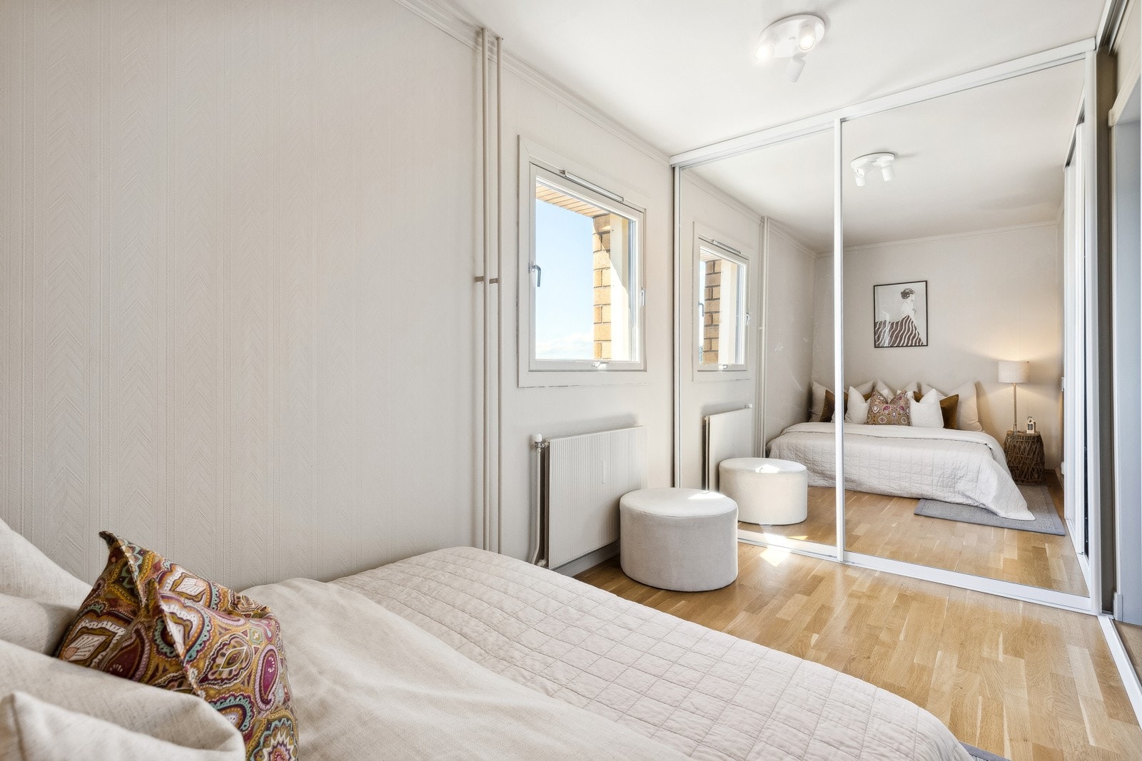 Lyst soverom med garderobeskap med speilfronter Galleribilde