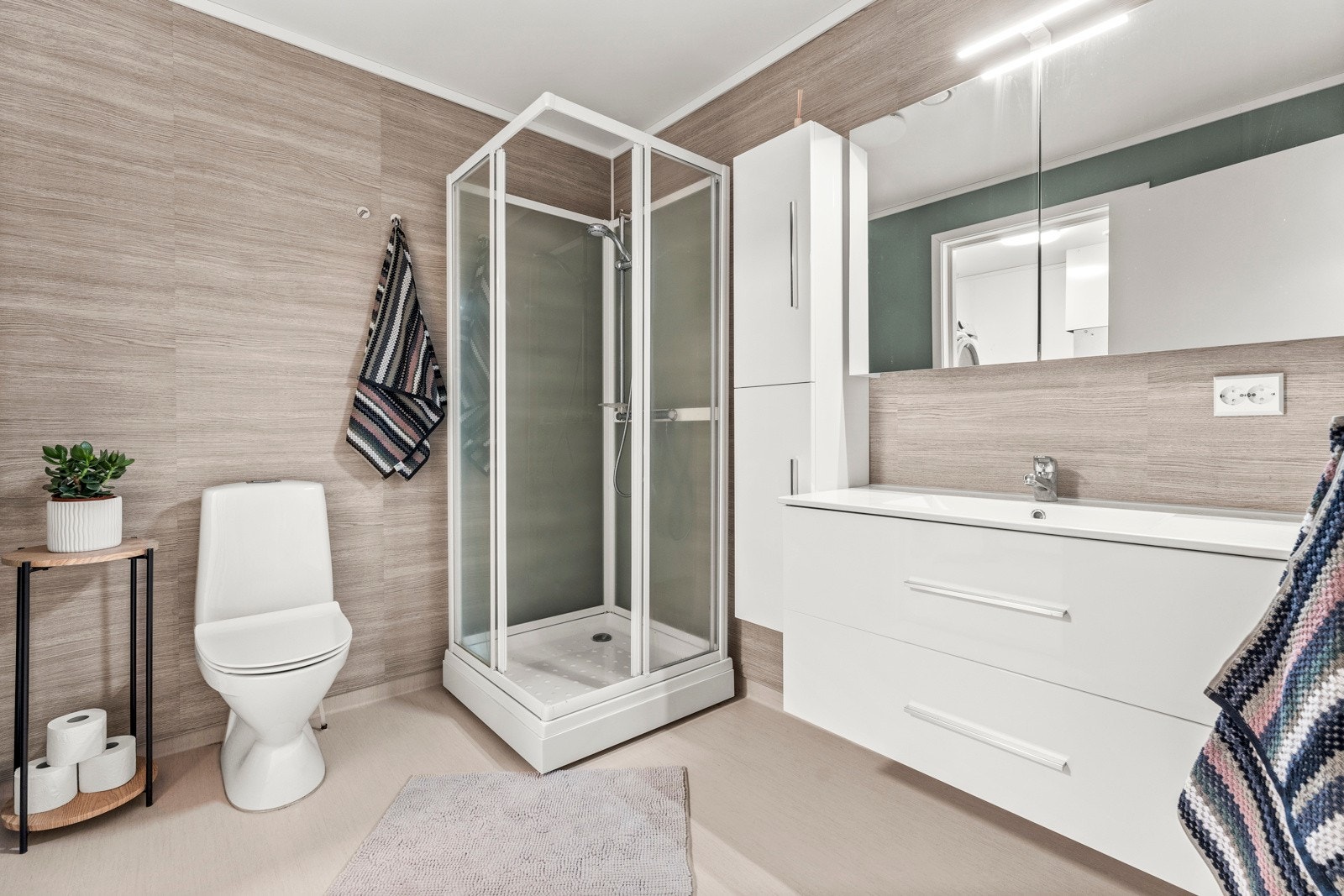 Romslig baderom i lune farger og med dusjkabinett Galleribilde