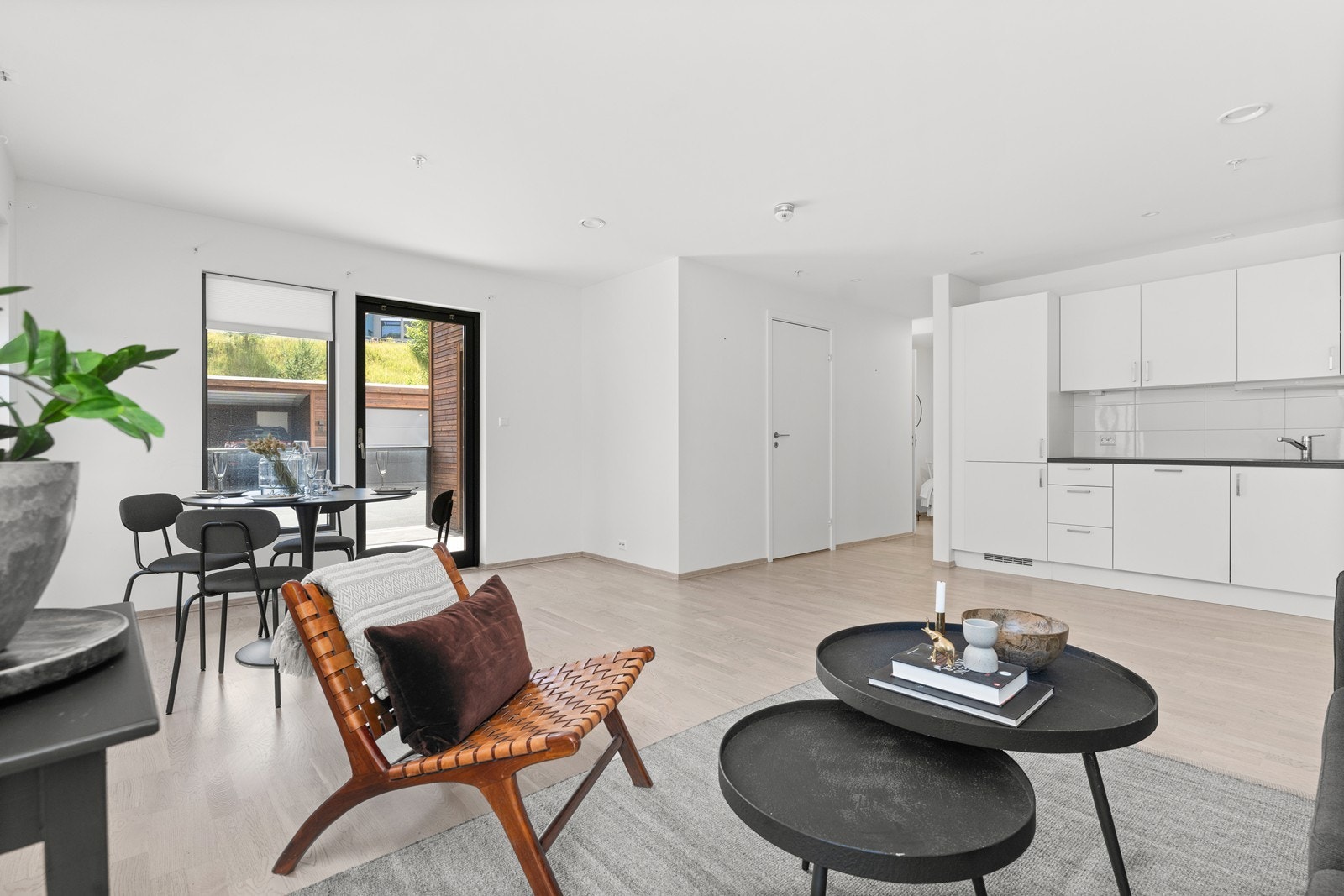 Stua har åpen løsning til kjøkken, og plass til både sitte- og spisegruppe Galleribilde