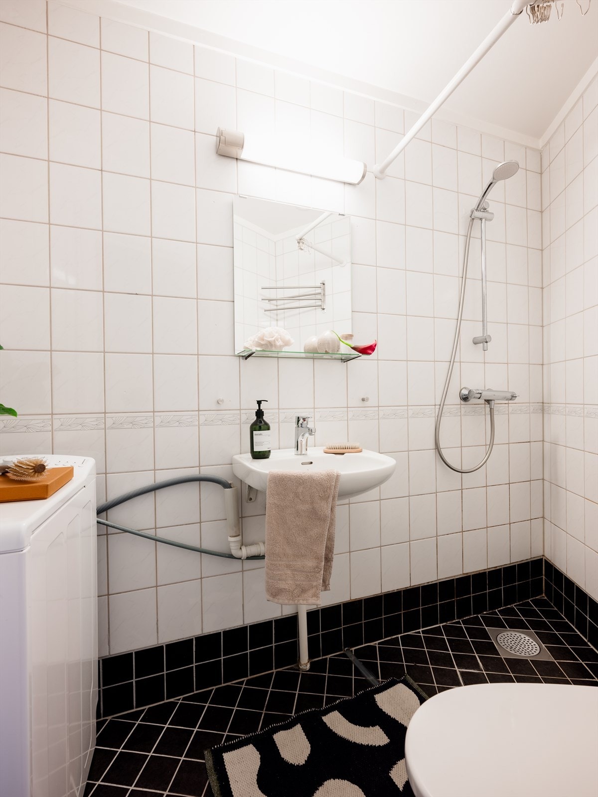 Videre er rommet innredet med dusjhjørne, klosett og servant, samt opplegg og plass til vaskemaskin. Galleribilde