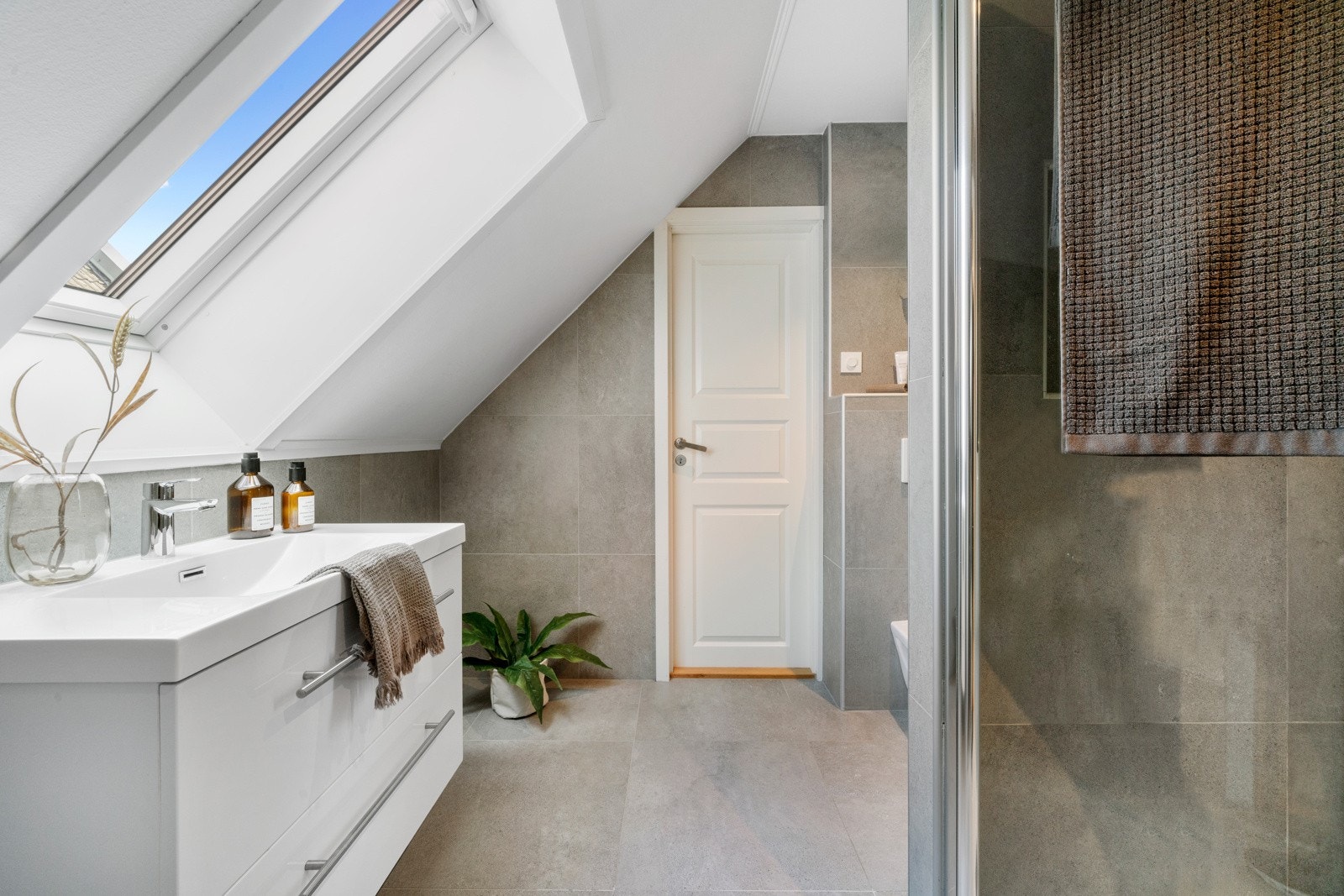 Innredning består av vegghengt wc, dusj med glass foldedører og servant med pent møblement. Galleribilde