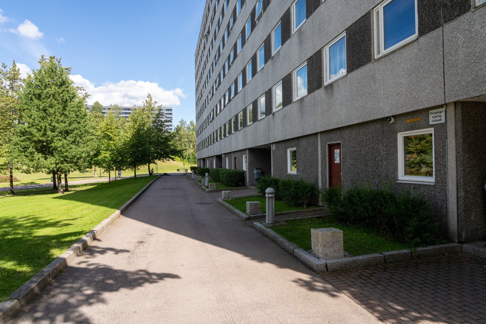 Asfalterte internveier med beplantning, sittegrupper og lekeplasser i borettslagets fellesareal. Galleribilde