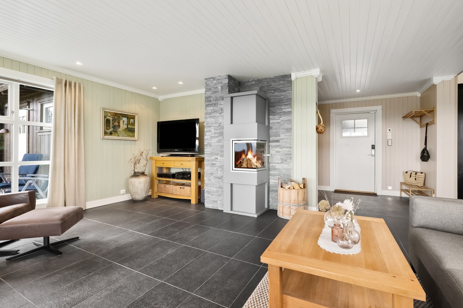 Stuen har flott ildsted som setter preg på den flotte hytten Galleribilde