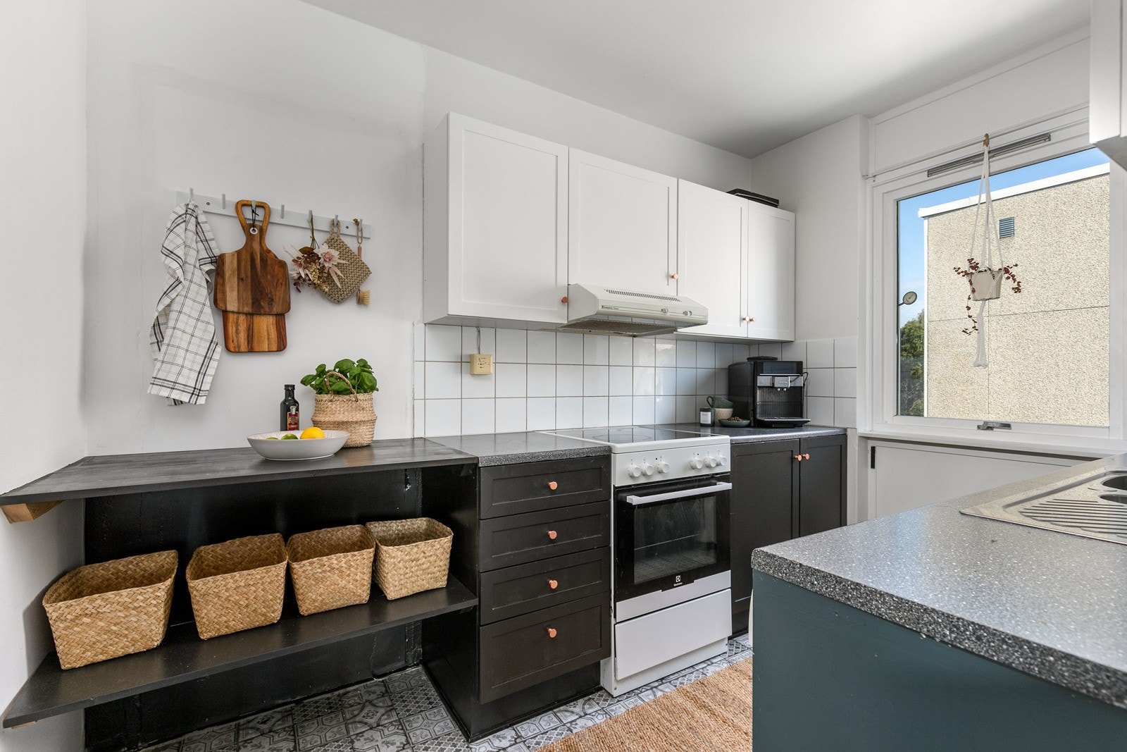 Separat kjøkken av ukjent alder. Innredningen består av profilerte skap- og skuffefronter i malt utførelse og laminert benkeplate med nedfelt vaskekum i rustfritt stål. Det er satt inn fliser mellom over og underskap, samt belysning. Galleribilde