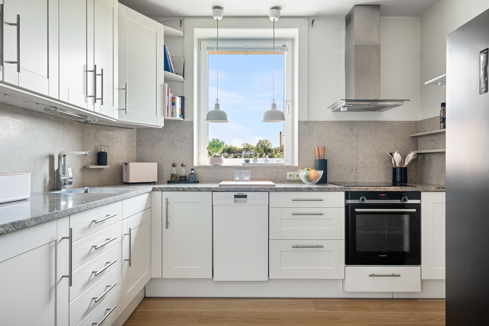Innredningen er lys og moderne med profilerte fronter og benkeplate i solid stein. Galleribilde