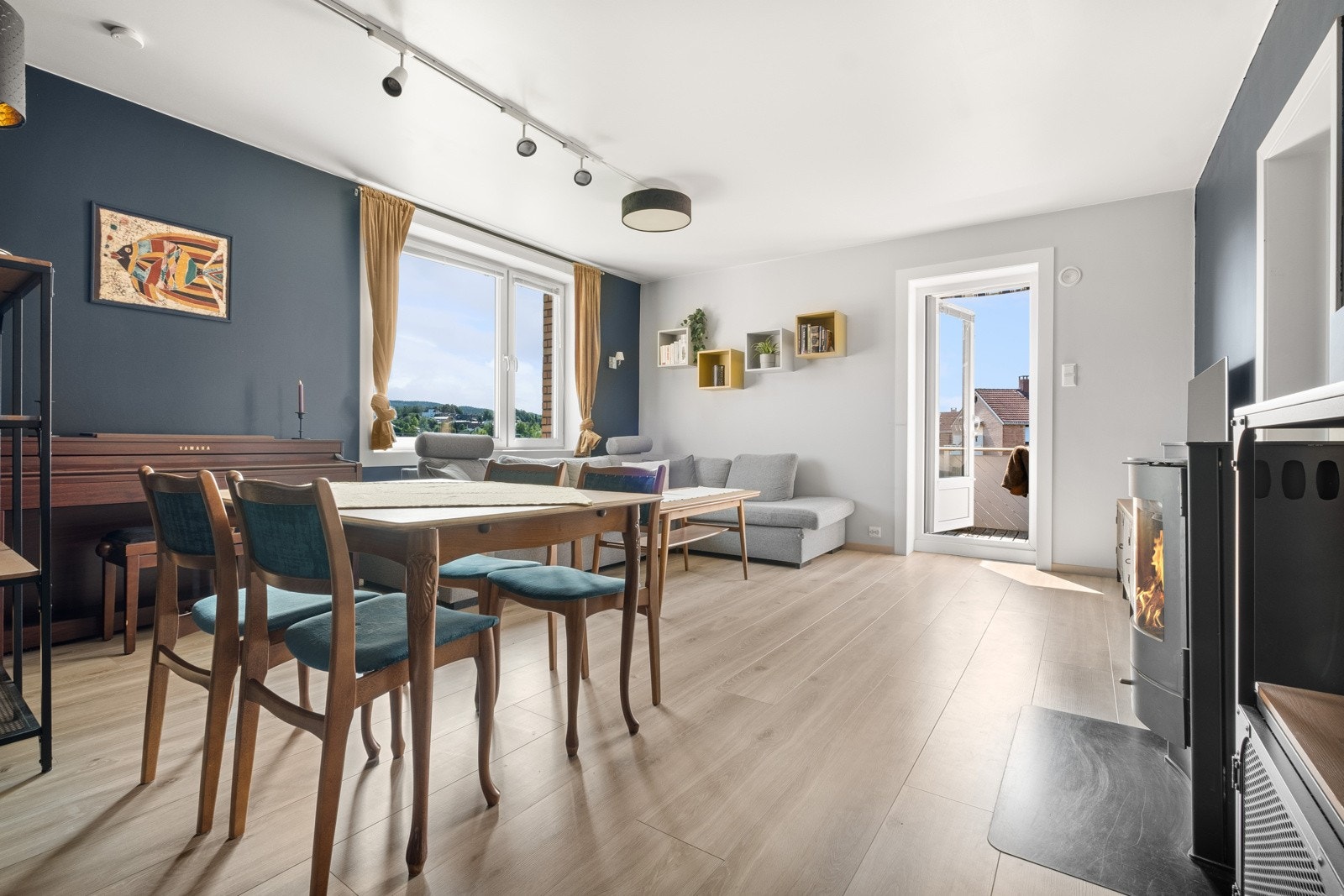 Leiligheten har en lys og moderne stue med peisovn. Galleribilde