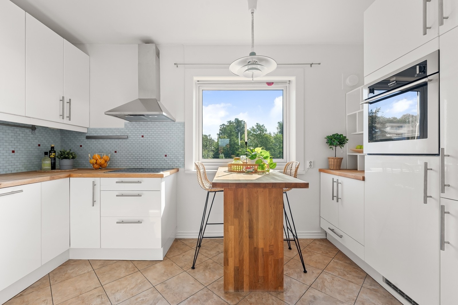 Separat og moderne kjøkken som består av lyse fronter og benkeplate i heltre. Galleribilde