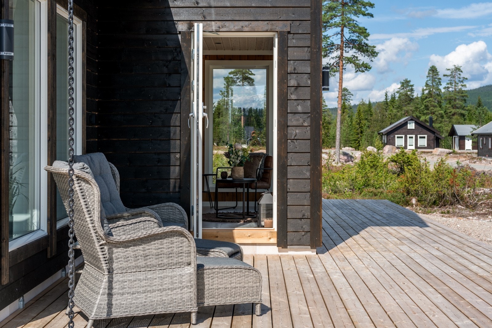 Dør fra stuen til terrassen. Her har man sol fra morgen til kveld på denne terrassen som dekker 2 sider av hytta. Galleribilde