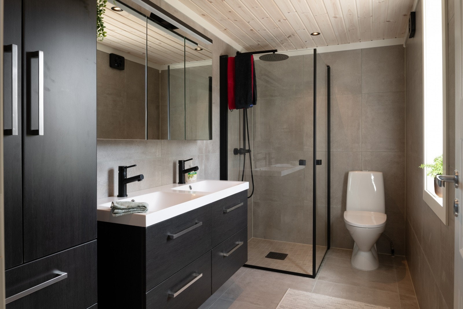 Stort, flislagt bad med varmekabler, 90x90 innsvingbare dusjdører, dobbel vask på 120 cm, praktisk høyskap Galleribilde