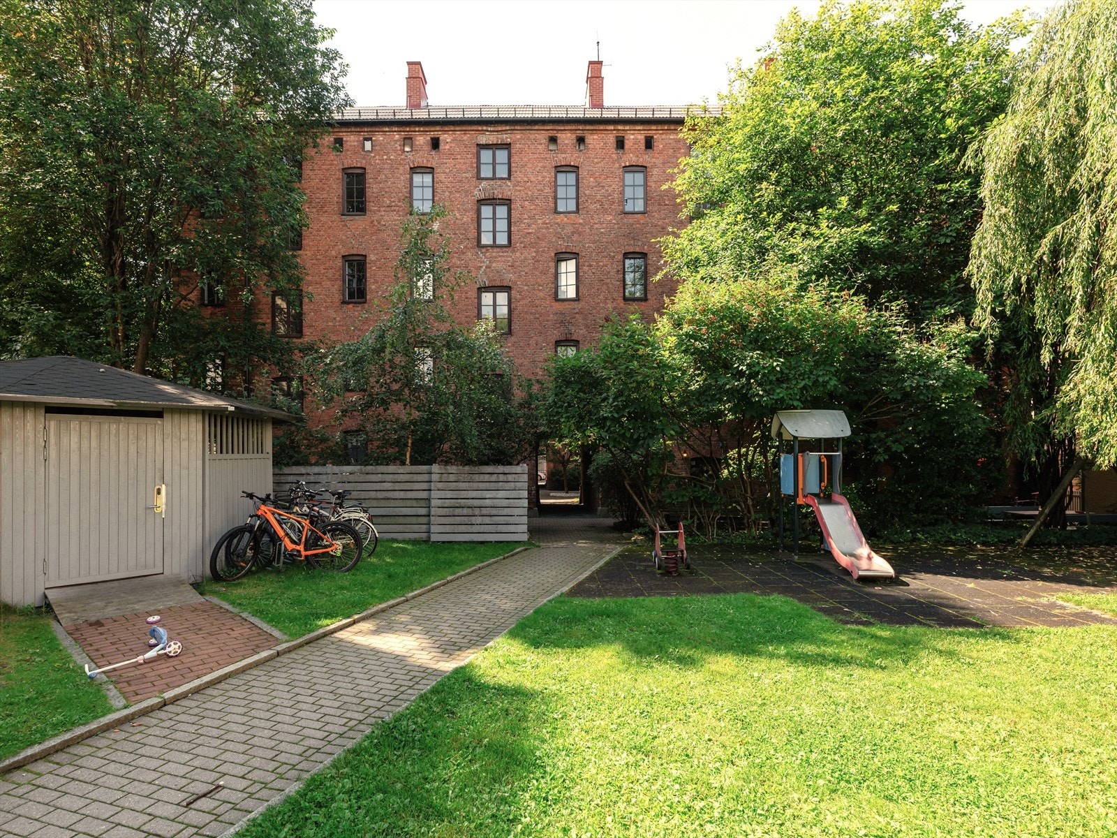 Bakgården har sykkelparkering, lekeapperater og herlige grøntarealer til glede for store og små. Galleribilde