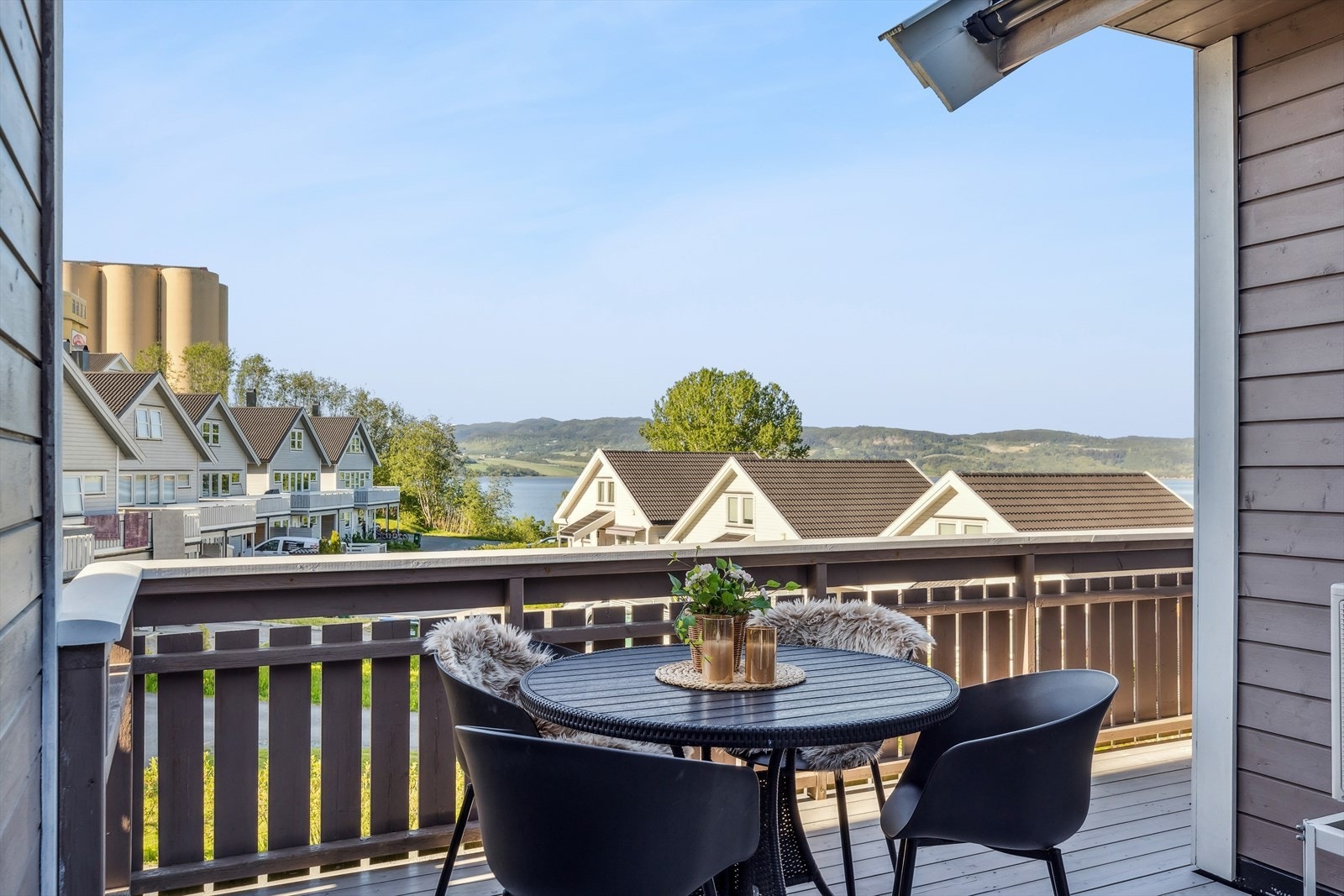 Veranda i forkant av boligen går over i en skjermet terrasse mellom boligen og nabobygget. Galleribilde