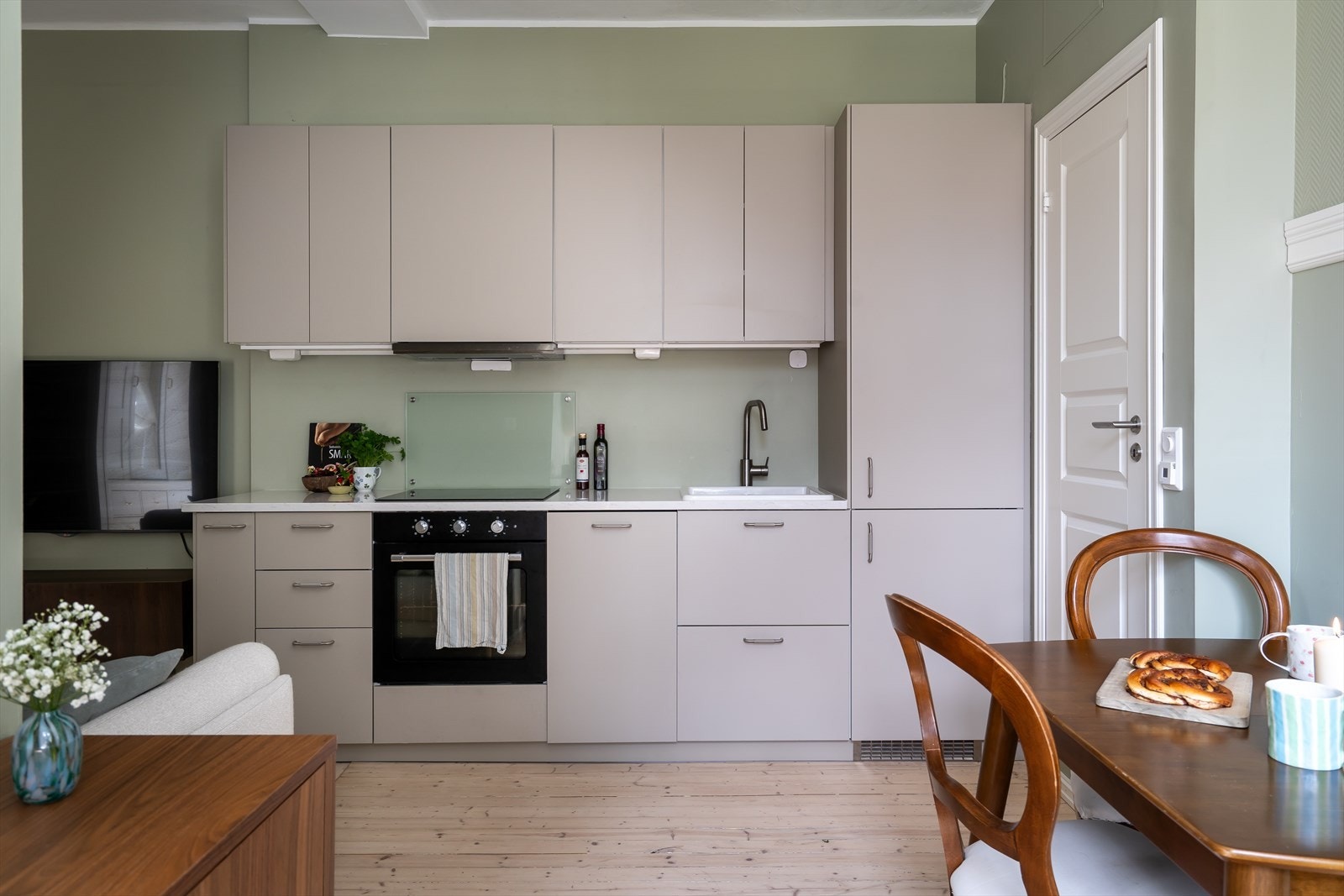 Stilrent IKEA-kjøkken fra 2023. Kjøkkeninnredningen består av beige glatte fronter med lys steinbenkeplate. Galleribilde