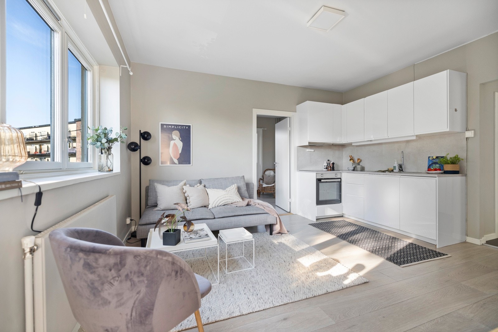 Stue med åpen kjøkkenløsning med plass til sofa- og spisegruppe med tilhørende møblement. Galleribilde