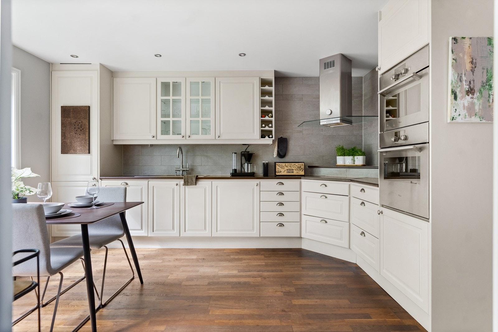 Kjøkkenet har tidløse fargetoner og integrerte hvitevarer. Det er grå fliser over benken som matcher interiøret. Galleribilde