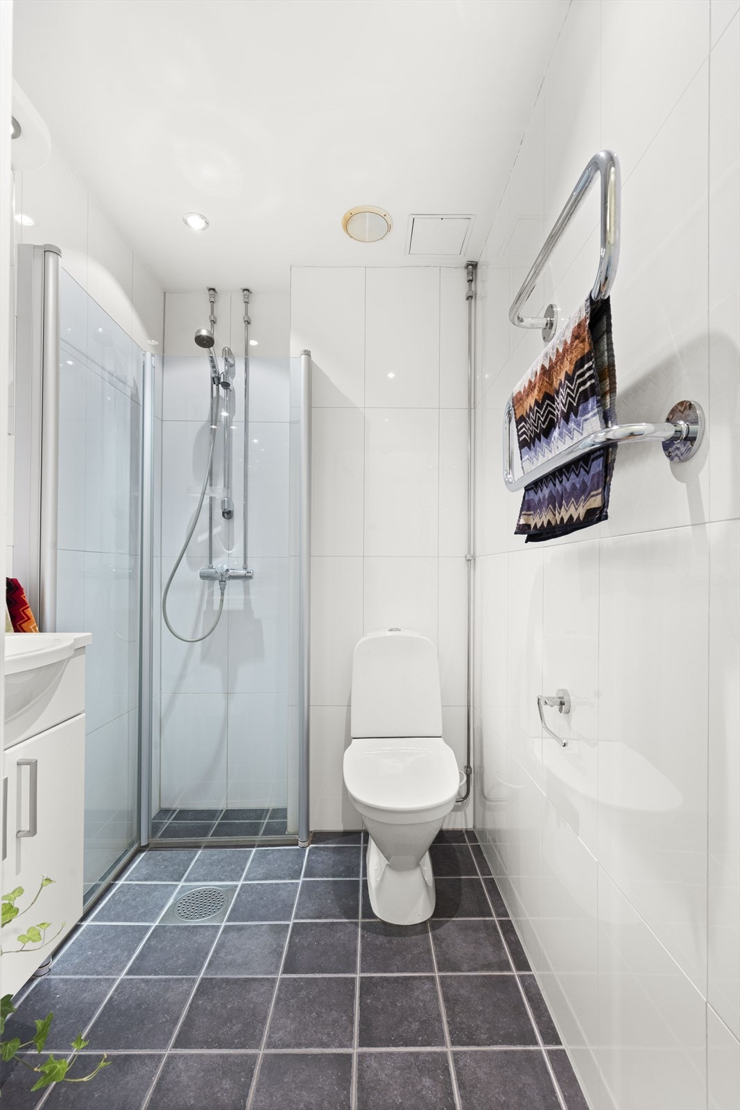 Badet har varmekabler i gulv, downlights i tak og dushjørne med innfellbare glassdører Galleribilde