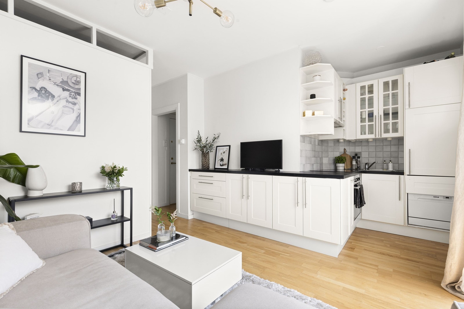 Selve kjøkkenet har bra med skap og benkeplass, samt integrerte hvitevarer som kjøleskap, komfyr og induksjonstopp Galleribilde