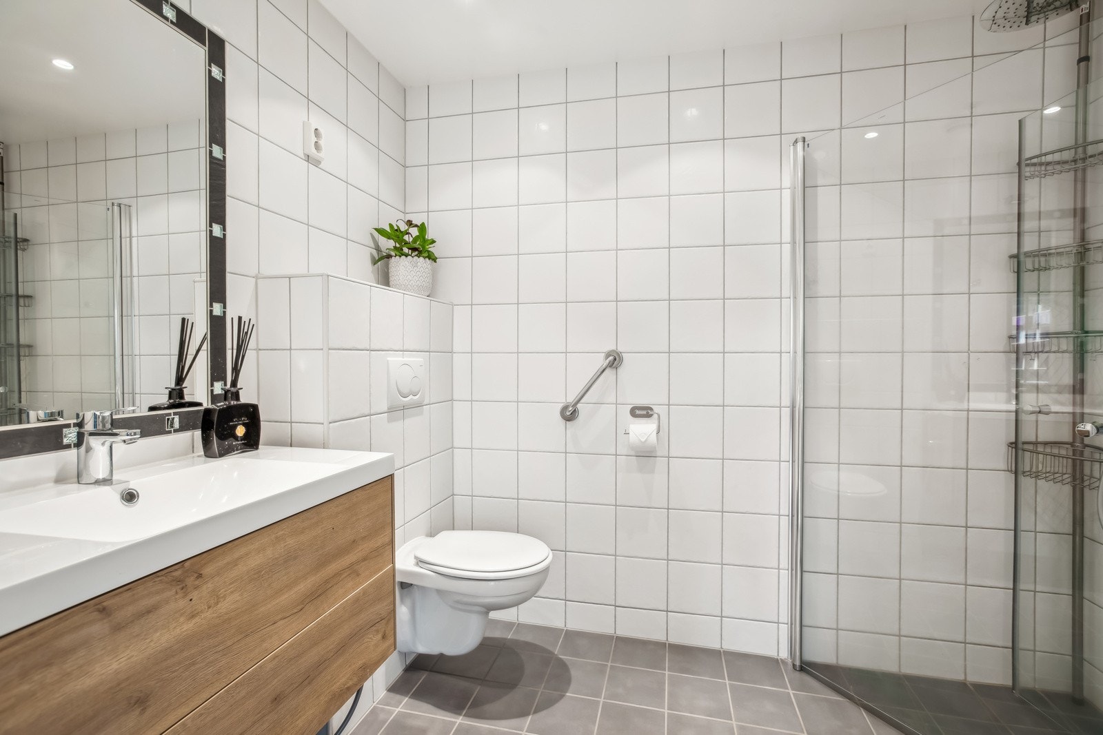 Badet er utstyrt med vegghengt toalett og hjørnedusj med sammenleggbare dører. Galleribilde