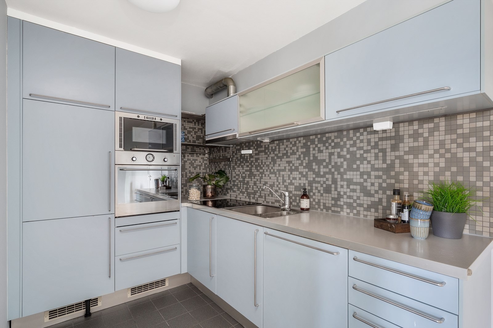 Kjøkkenet har innredning med glatte fronter og en benkeplate i laminat som gir et stilrent og funksjonelt preg. Galleribilde