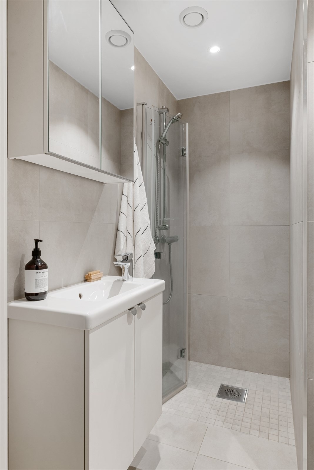 Flislagt baderom med varme i gulvet og downlights i himling. Galleribilde