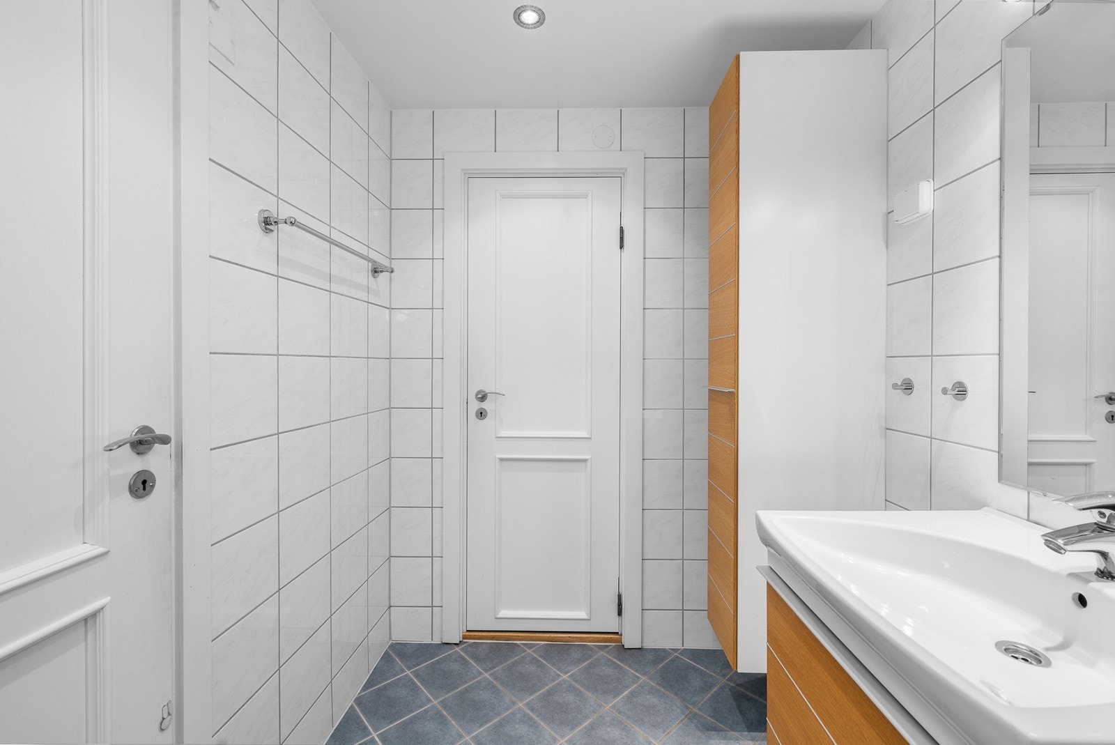 Baderomsinnredningen består av dusjhjørne, heldekkende servant med underskap og speil med belysning, i tillegg er det opplegg og plass for vaskemaskin/tørketrommel. Galleribilde