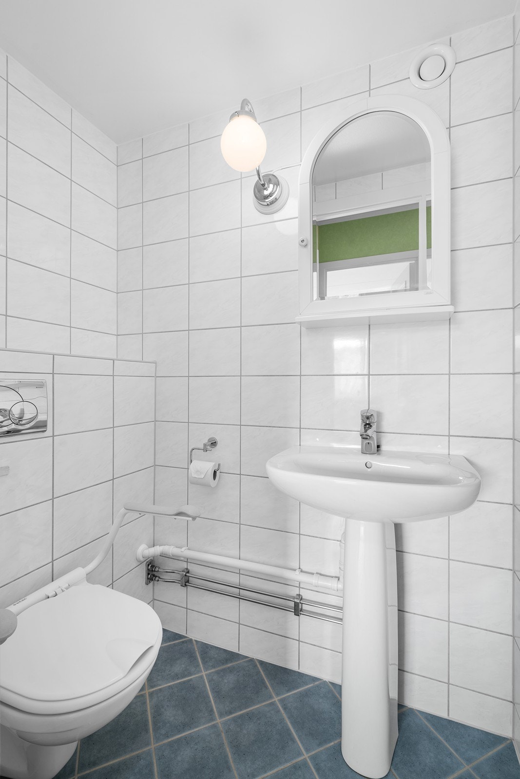 Leiligheten har et toalettrom som er flislagt på vegger og gulv. Innredningen består av vegghengt toalett, servant og speil med belysning. Galleribilde