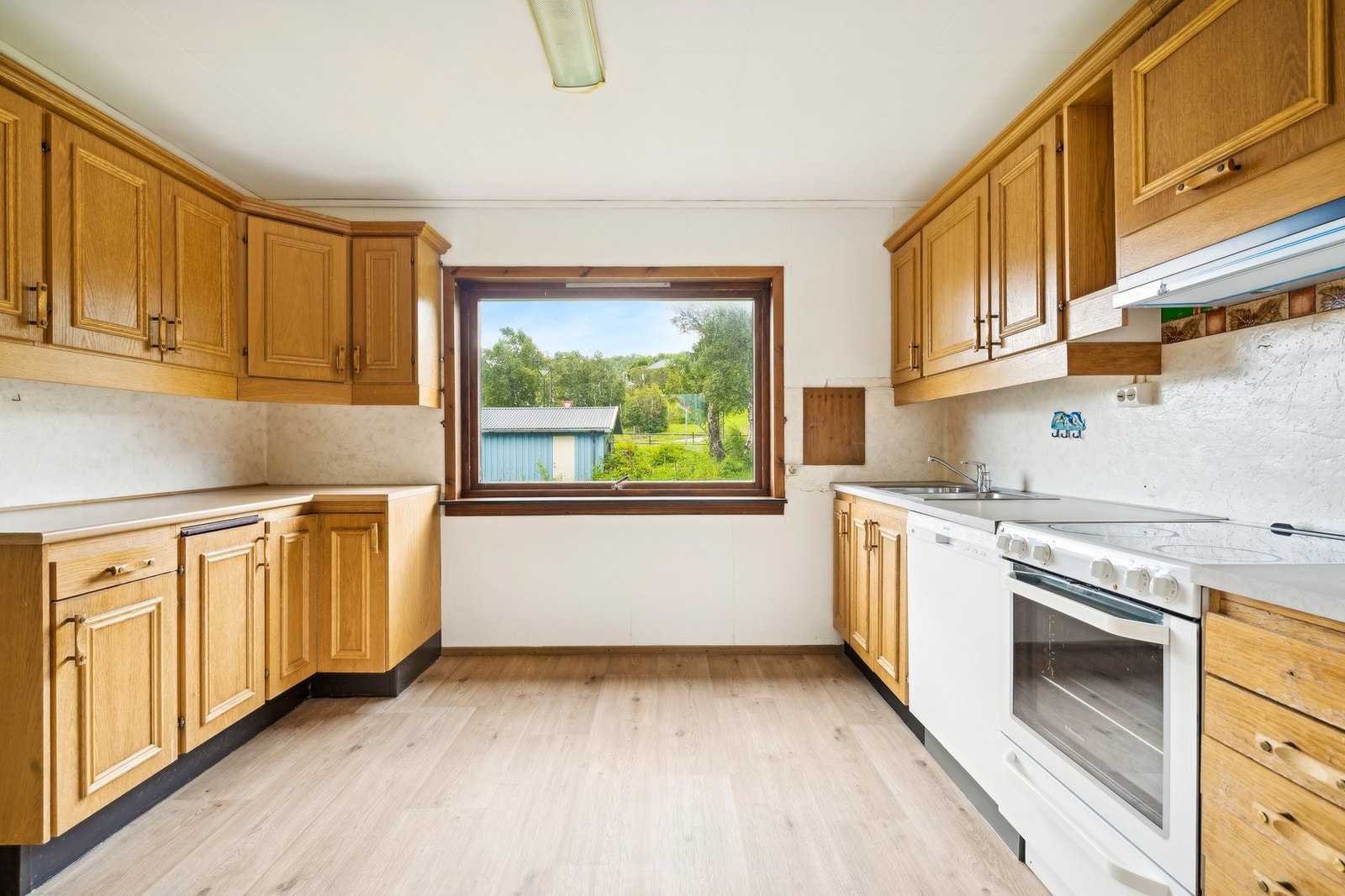 Kjøkkenet av eldre dato og har innredning med profilerte fronter og benkeplate av laminat Galleribilde