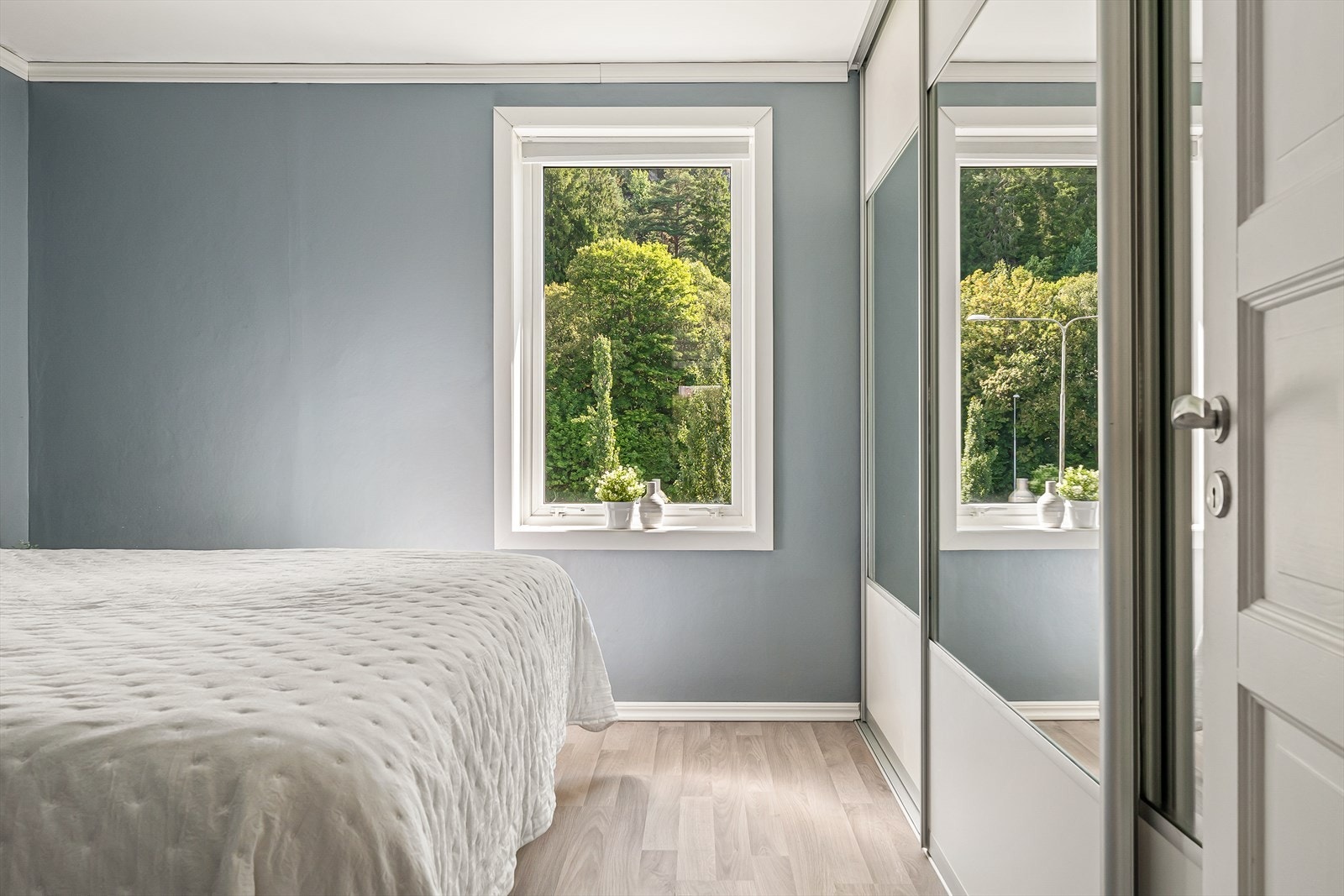 Stor og innholdsrik garderobe med speil og skyvedører. Galleribilde