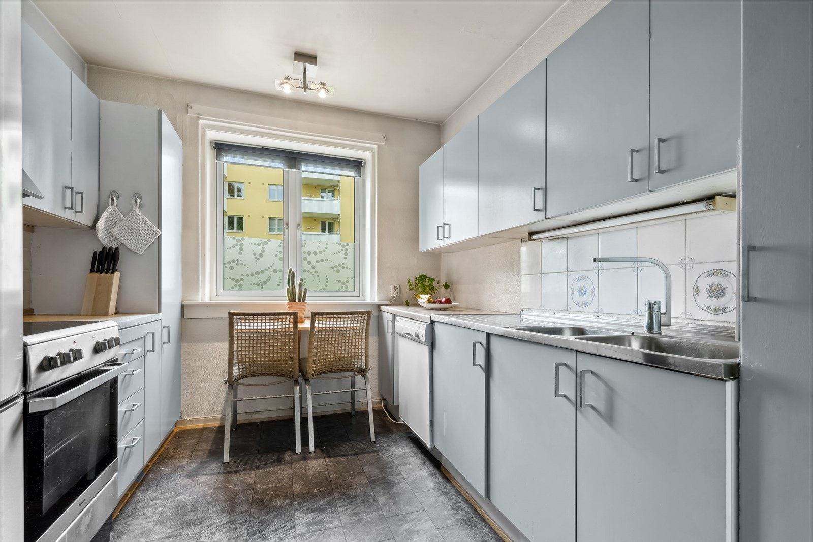 Kjøkken har benke- og overskap med slette fronter, benkeplate av laminat og fliser på vegg over benk. Galleribilde