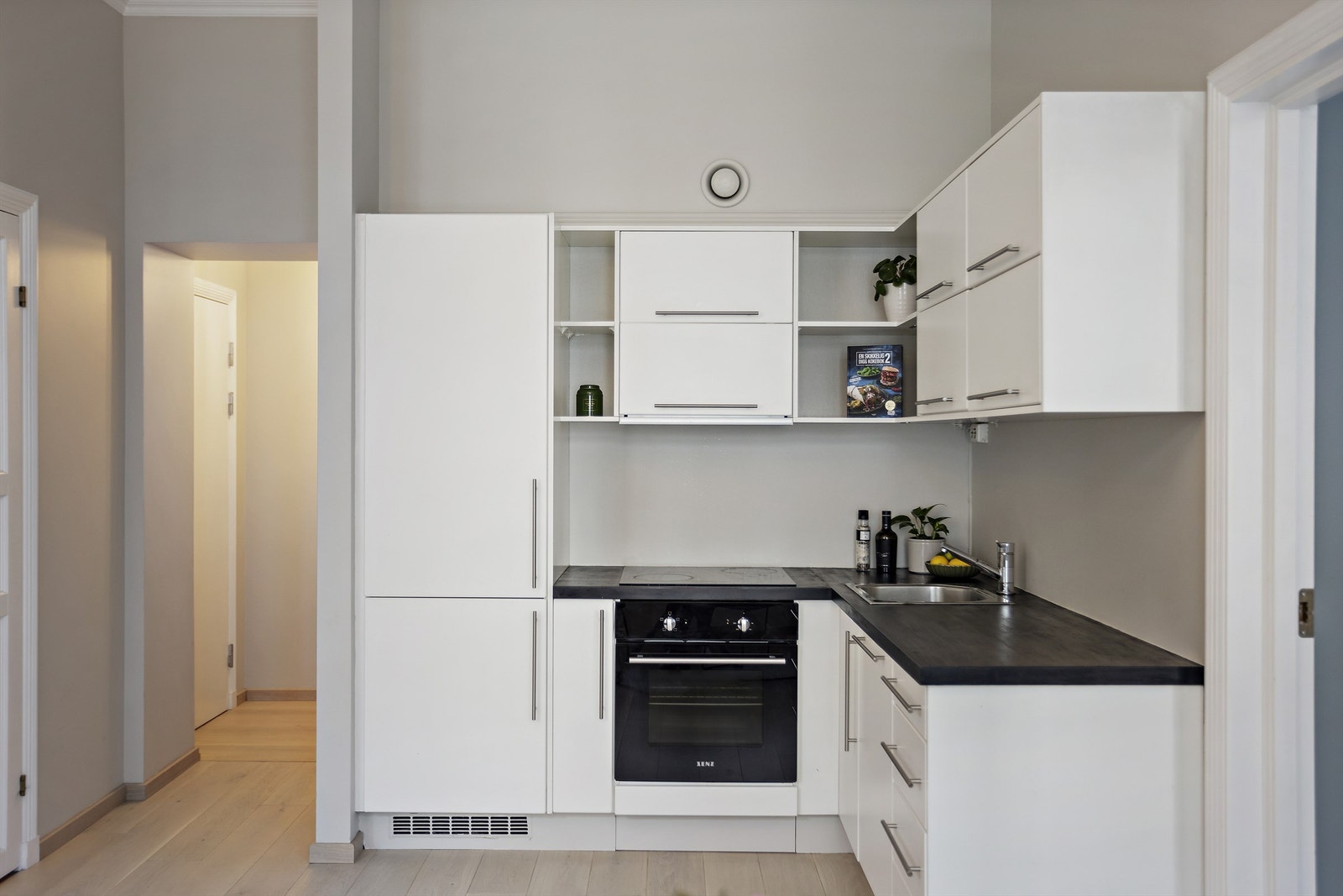 Kjøkkeninnredning med følgende hvitevarer: kjøleskap, fryser, vaskemaskin, oppvaskmaskin, integrert stekeovn og stekeplate. Galleribilde