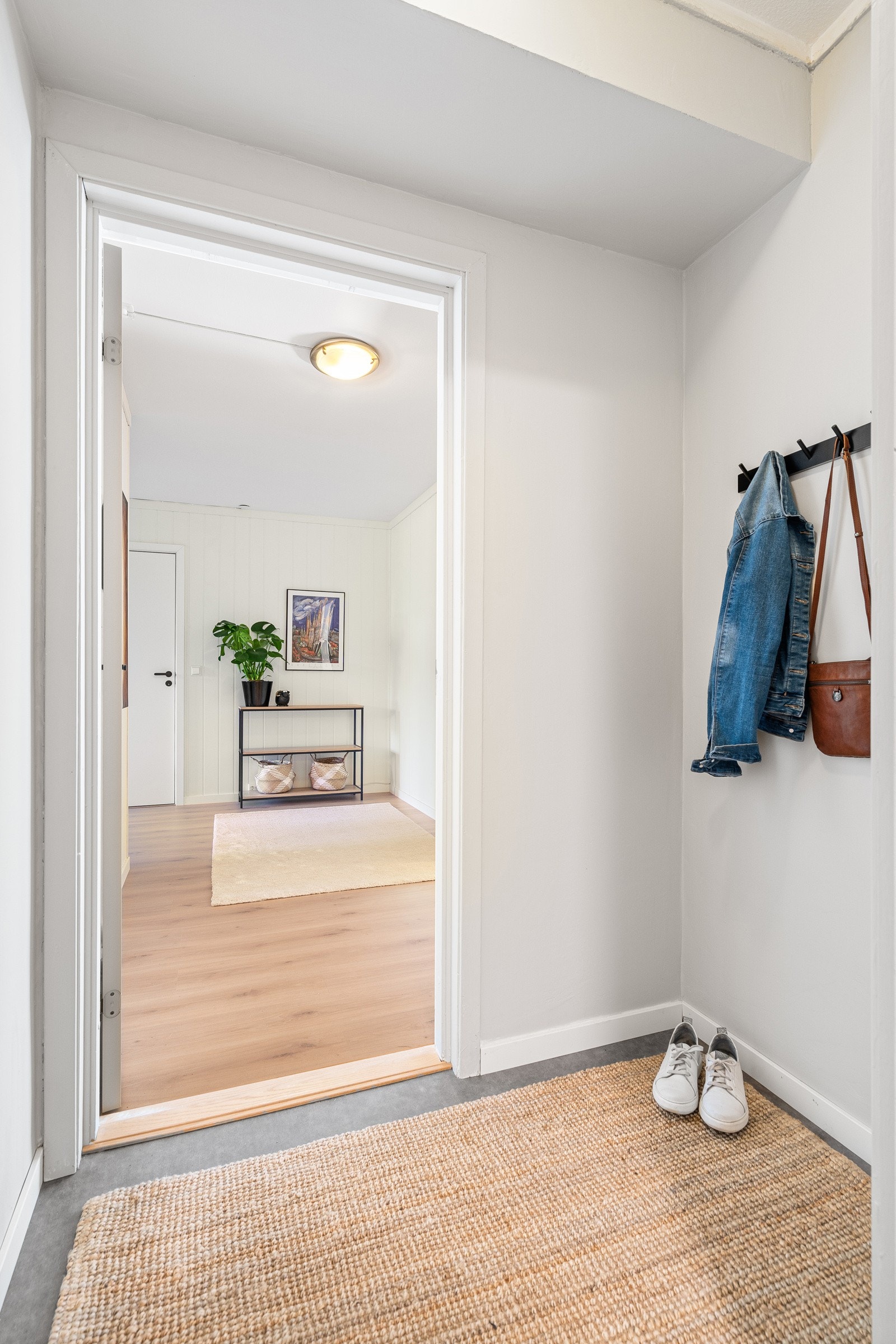 Velkommen inn! Her kommer man inn i en romslig og stilren entrè med flere oppbevaringsmuligheter for sko og ytterklær. Galleribilde