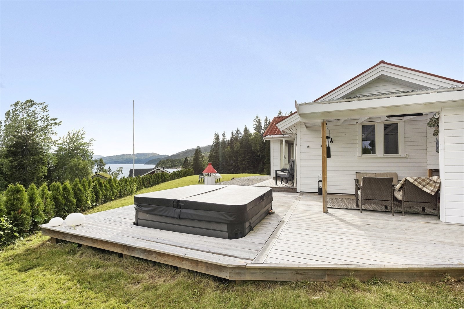 Uteområdet er perfekt for avslapning og sosialt samvær, med både jacuzzi og et utekjøkken bak pergola. Galleribilde