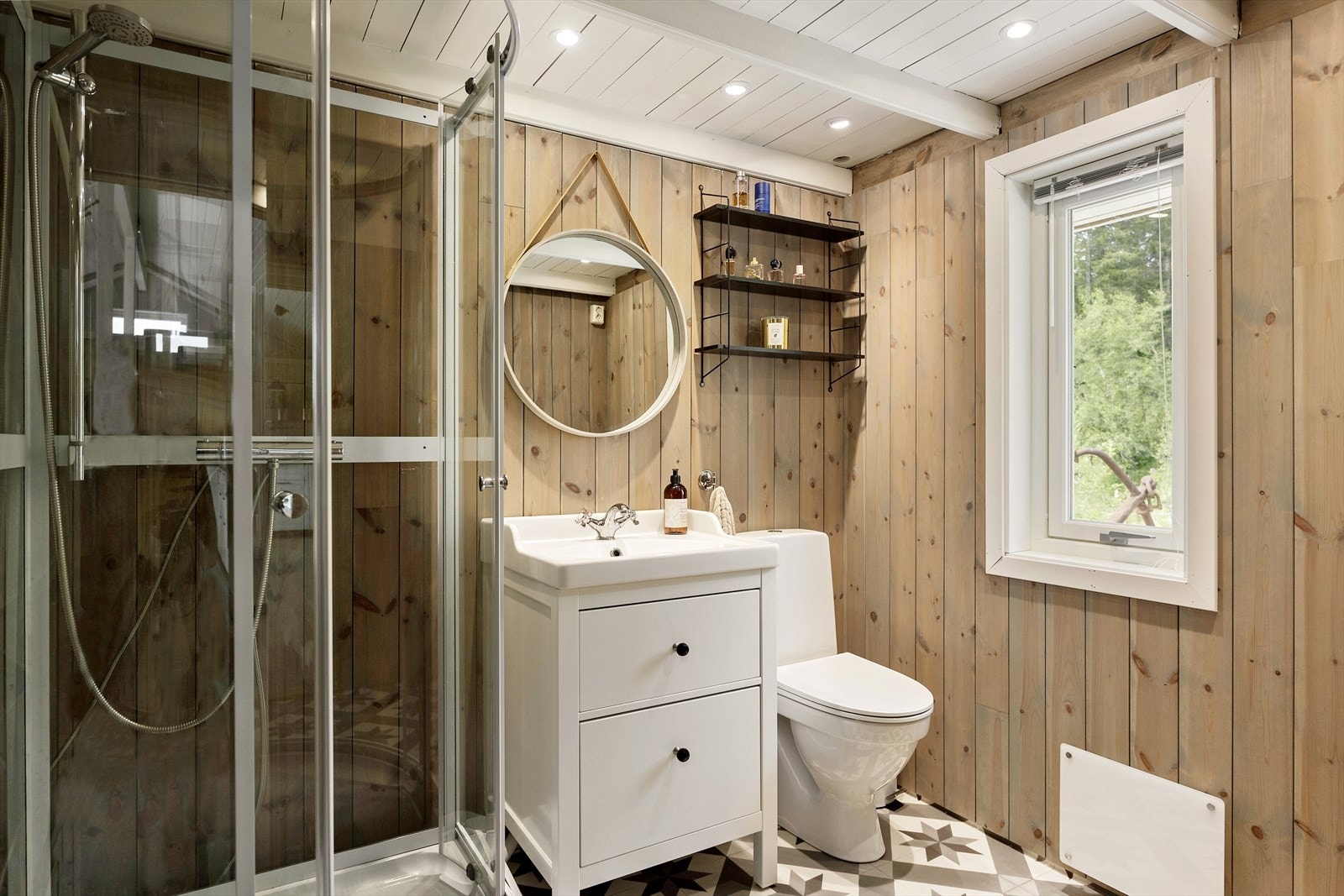 Badet holder samme moderne hyttestil som resten av boligen. Her med innredning med heldekkende servant og ett-greps blandebatteri, dusjkabinett og gulvmontert toalett. Galleribilde
