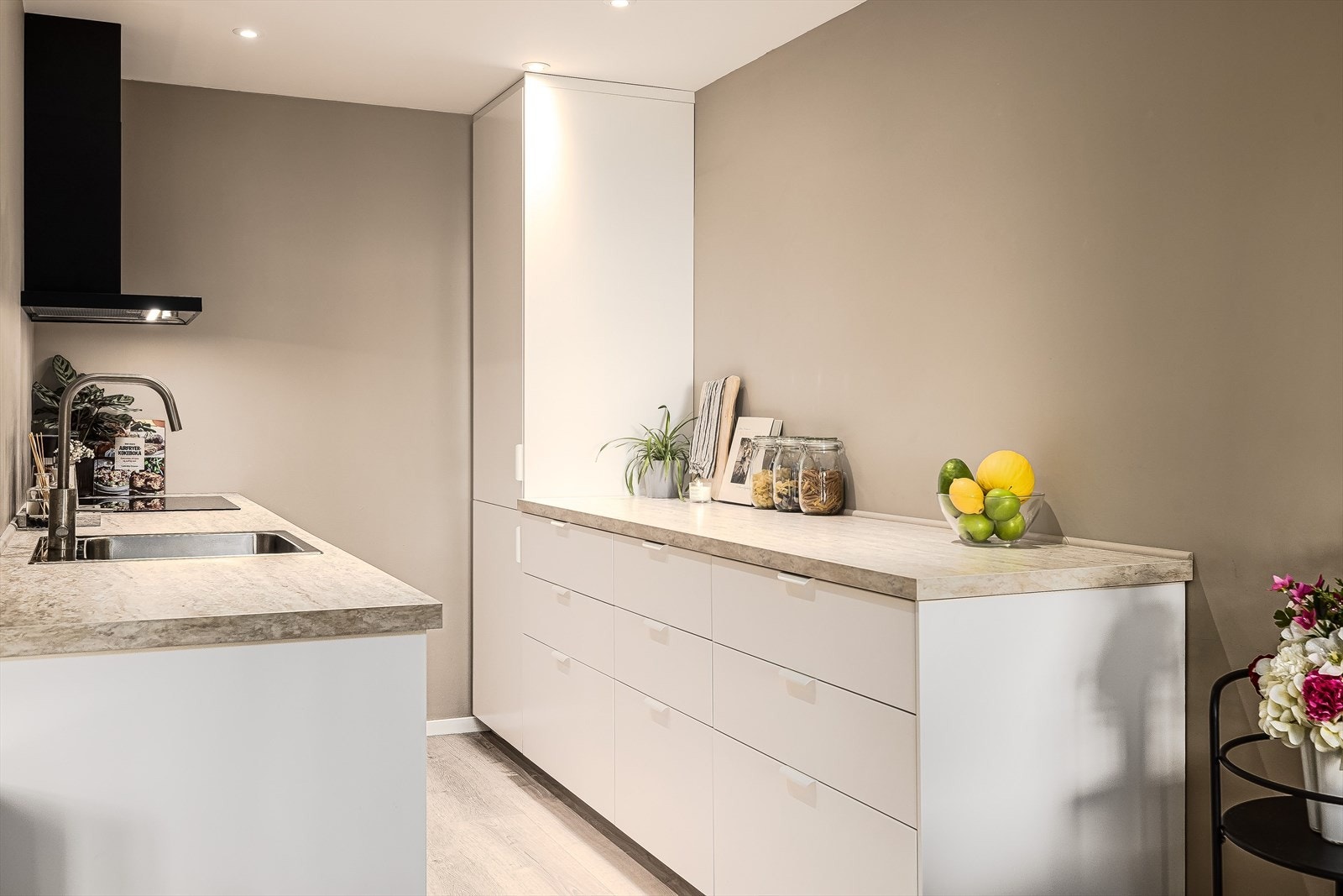 Kjøkkenet ligger i en fin delvis åpen løsning med stuen, naturlig adskilt og samtidig åpent og sosialt. Praktisk med innfelte downlights i himlingen. Galleribilde