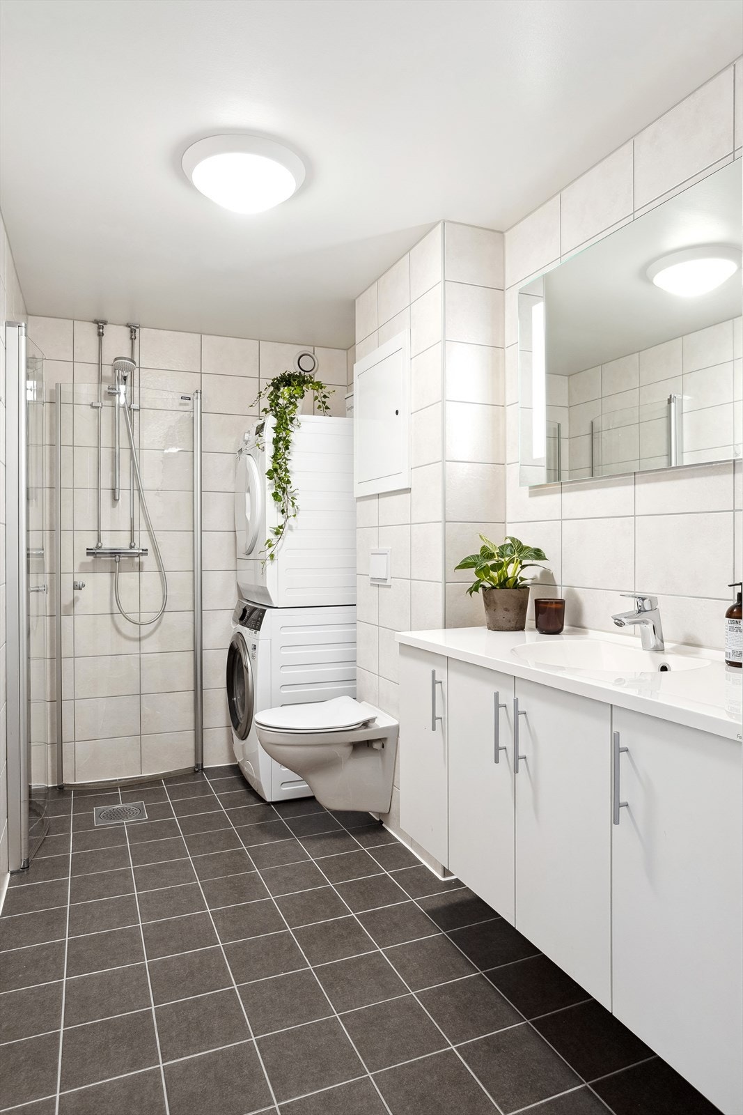 Stort flislagt bad som er renovert i regi av borettslaget i 2018. Opplegg for vaskemaskin og tørketrommel. Galleribilde