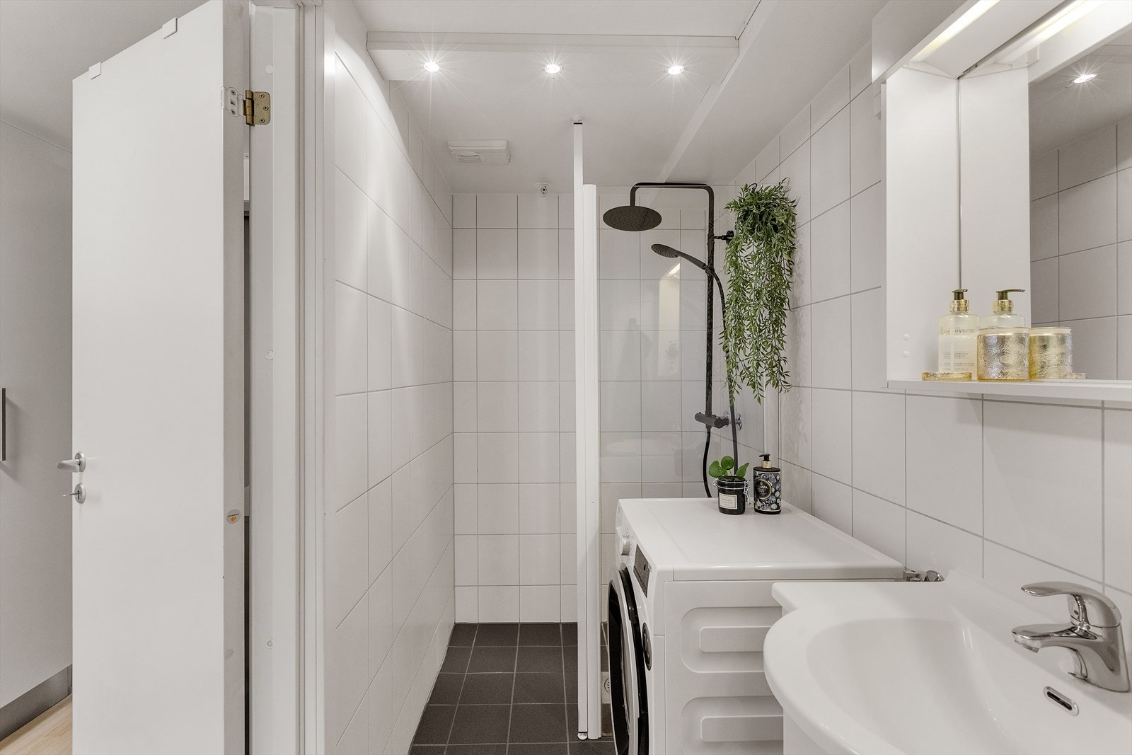 Tidløst og pent baderom med fliser, varmekabler og opplegg for vaskemaskin. Galleribilde