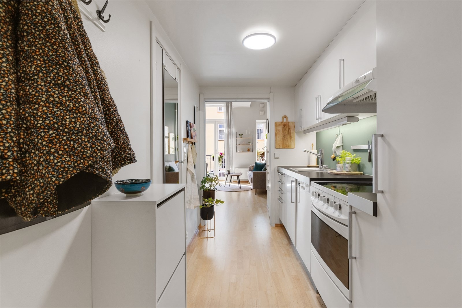 Kjøkken med stilrene hvite overflater. Godt med skap- og benkeplass. Galleribilde