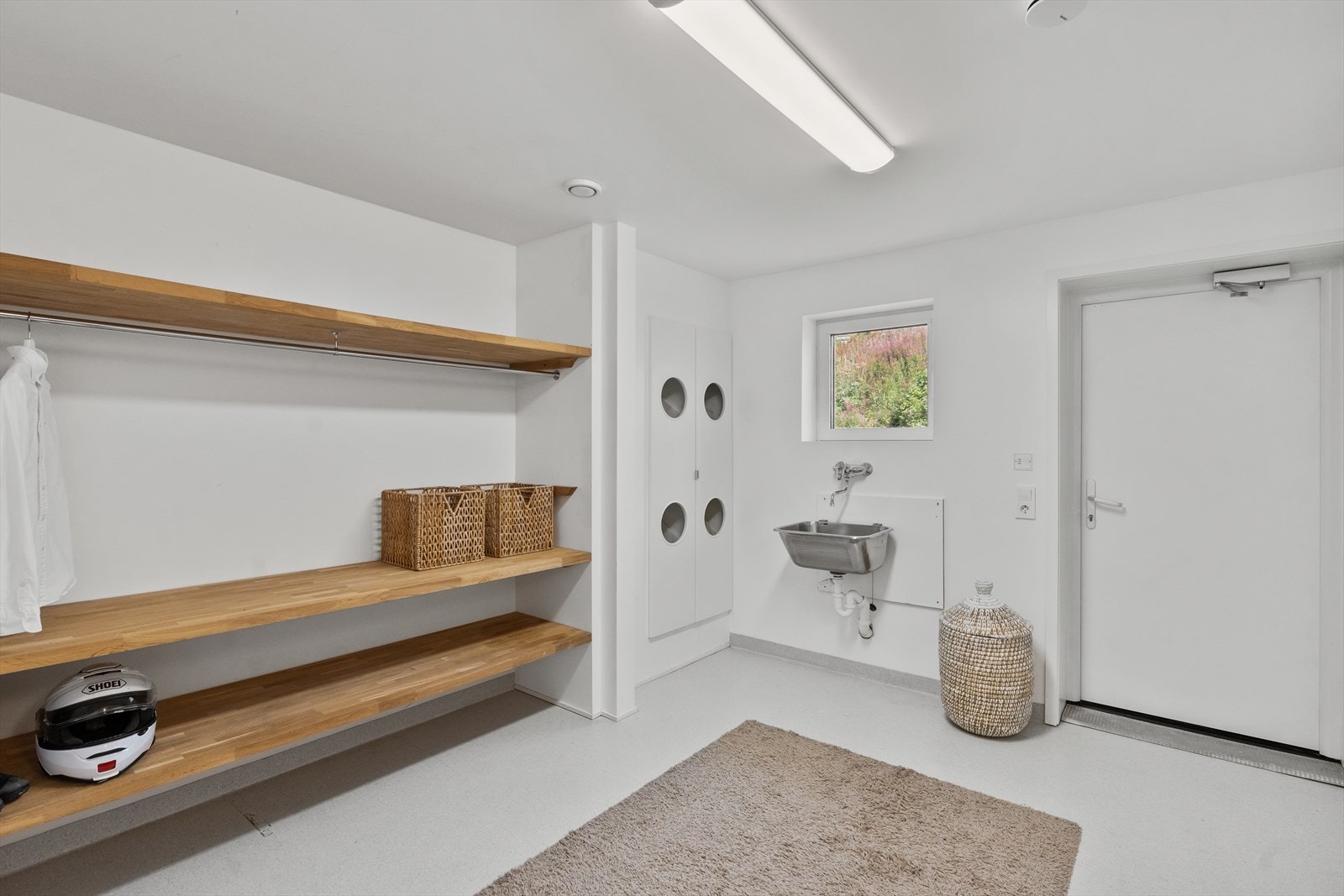 Romslig vaskerom med praktiske oppbevaringsløsninger, skittentøysjakt og god belysning. Direkte utgang til hage. Perfekt for en aktiv familie. Galleribilde