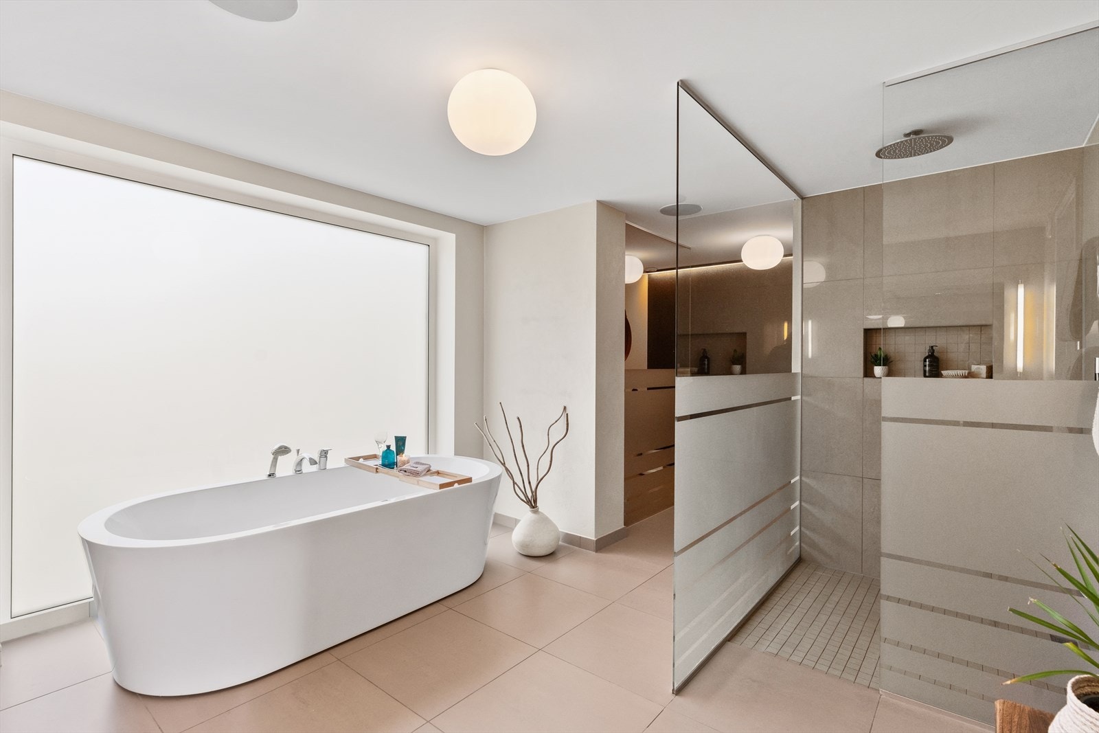 Bad/spaavdeling med badekar og dusjnisje som har vannfall fra tak. Baderommet har nydelige materialvalg. Galleribilde