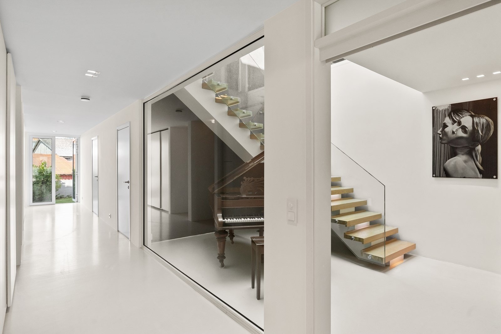 Trappen i hallen er egendesign med belysning og massive eiketrinn samt rekkverk i glass Galleribilde