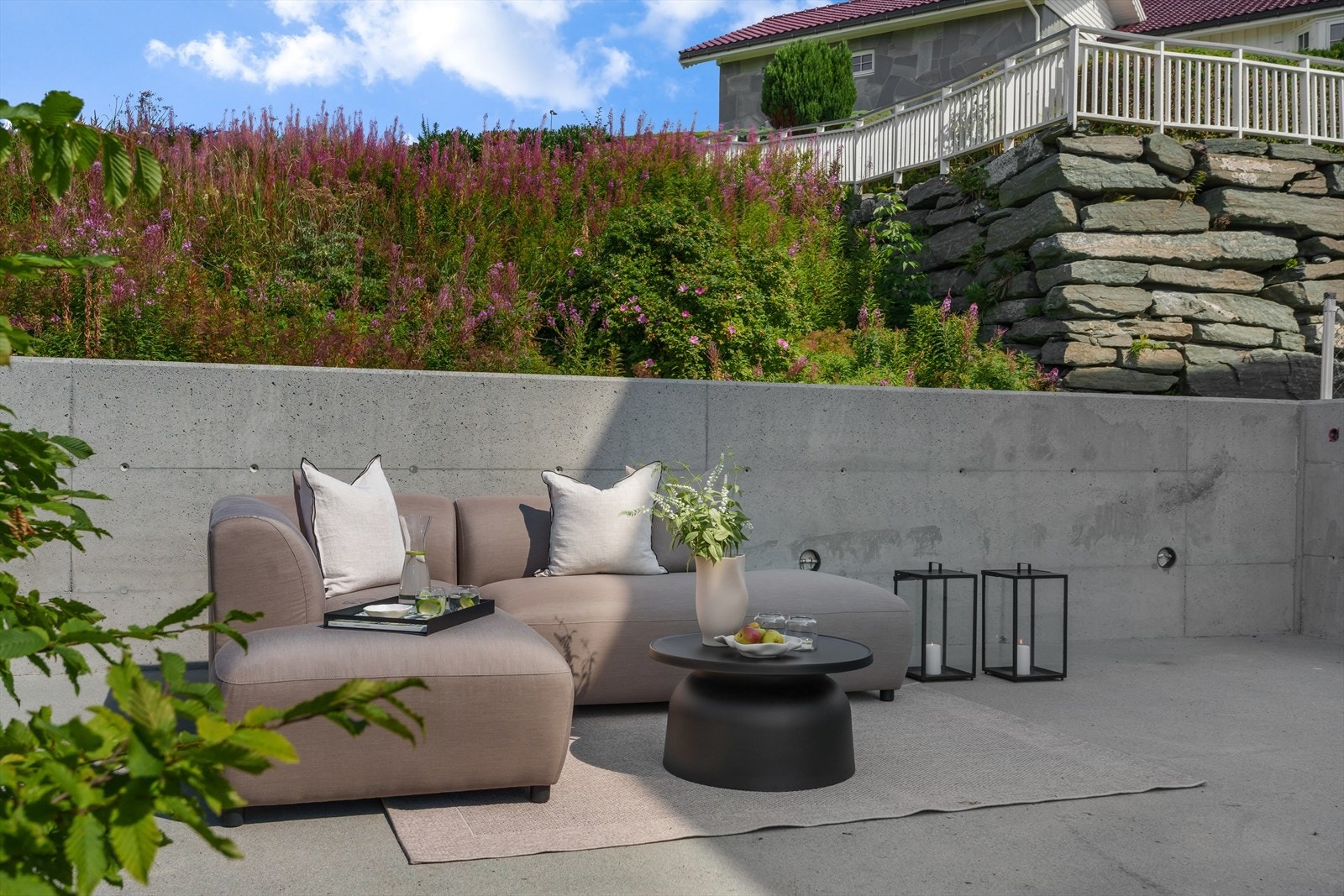 Boligen har forskjellige nydelige uteplasser og lounger hvor en alltid vil finne ly for vind og kunne nyte sommerdagen Galleribilde