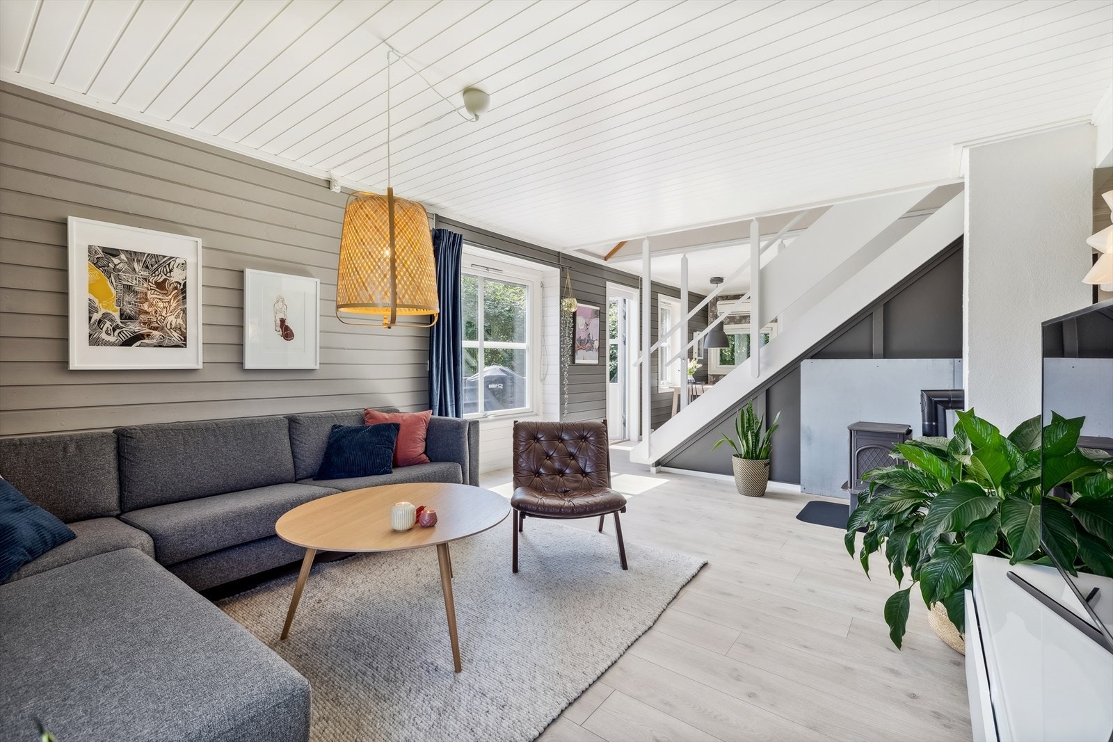 Stuen er et hyggelig rom med nyere laminatgulv og veggpanel malt i en rolig, harmonisk fargetone. Galleribilde